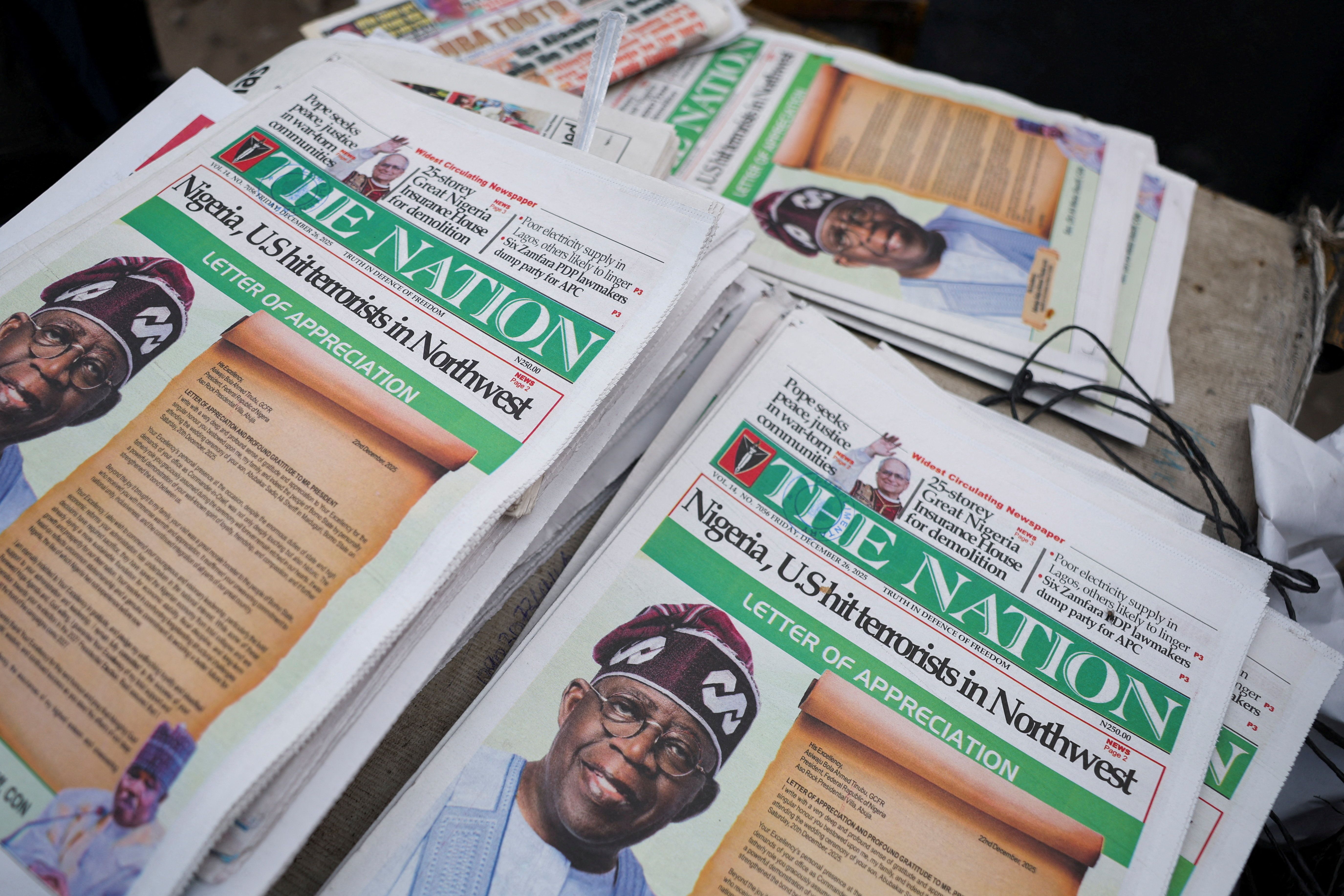 Front pages of newspapers reporting on U.S. airstrikes against Islamic State militants in Nigeria, according to U.S. President Donald Trump and the U.S. military, are displayed at a newspaper stall in Lagos, Nigeria, December 26, 2025. REUTERS/Sodiq Adelakun