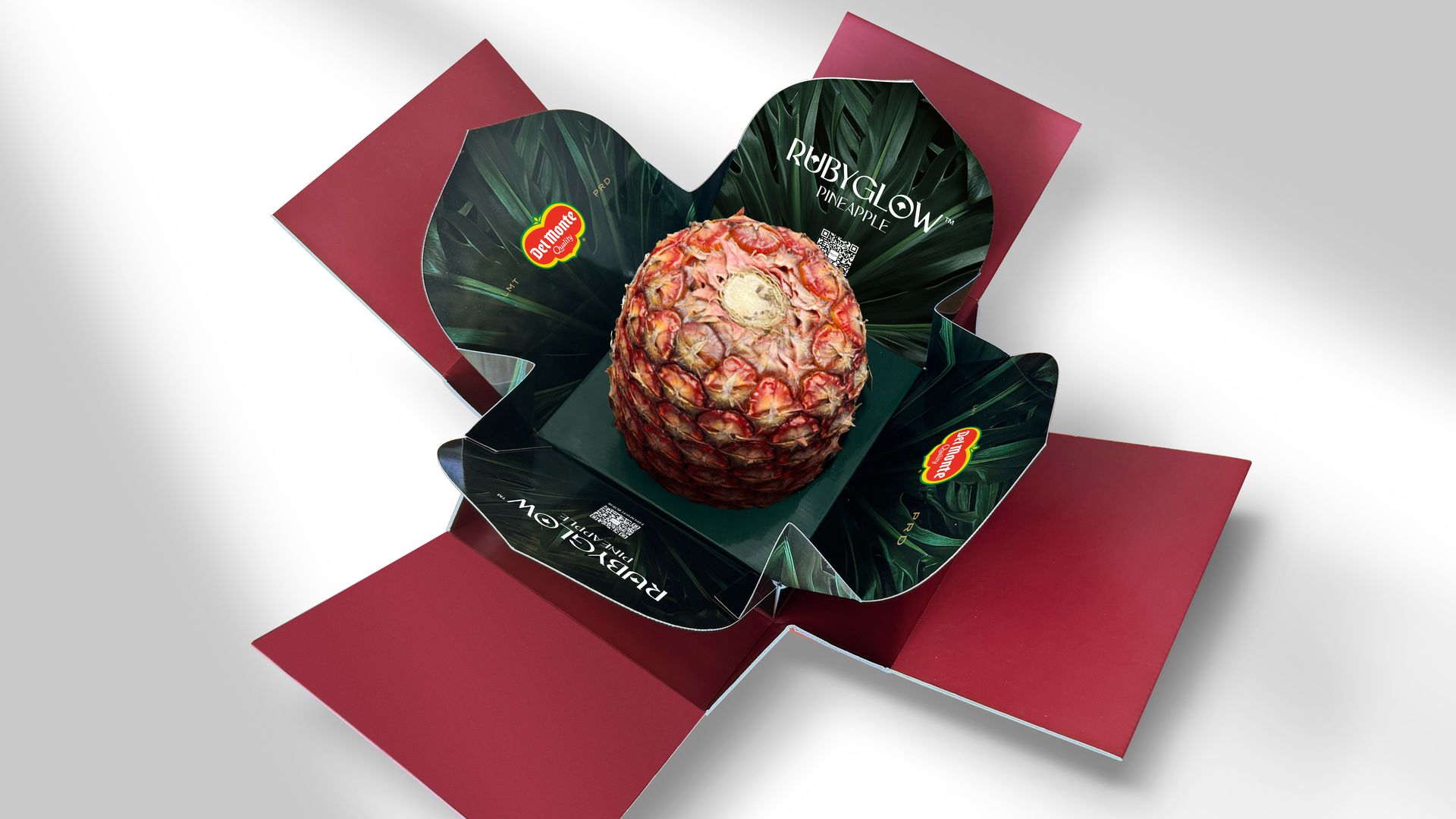 A red pineapple sits in an unfolded box.