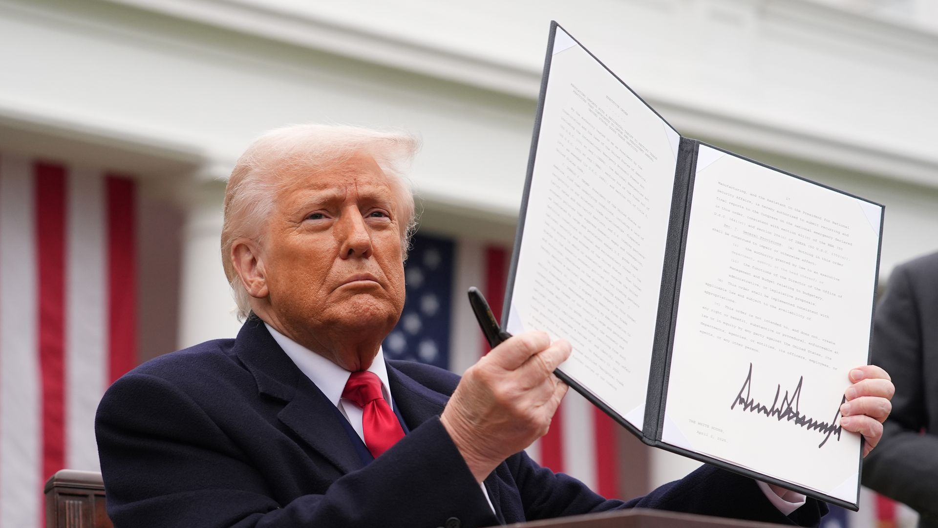 President Trump holds up a signed executive order at the White House.