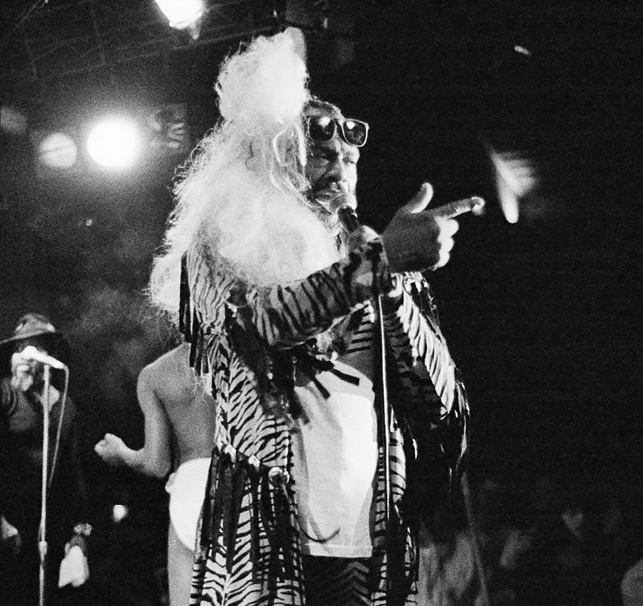 George Clinton performs on stage in a tiger print jacket in 1990.