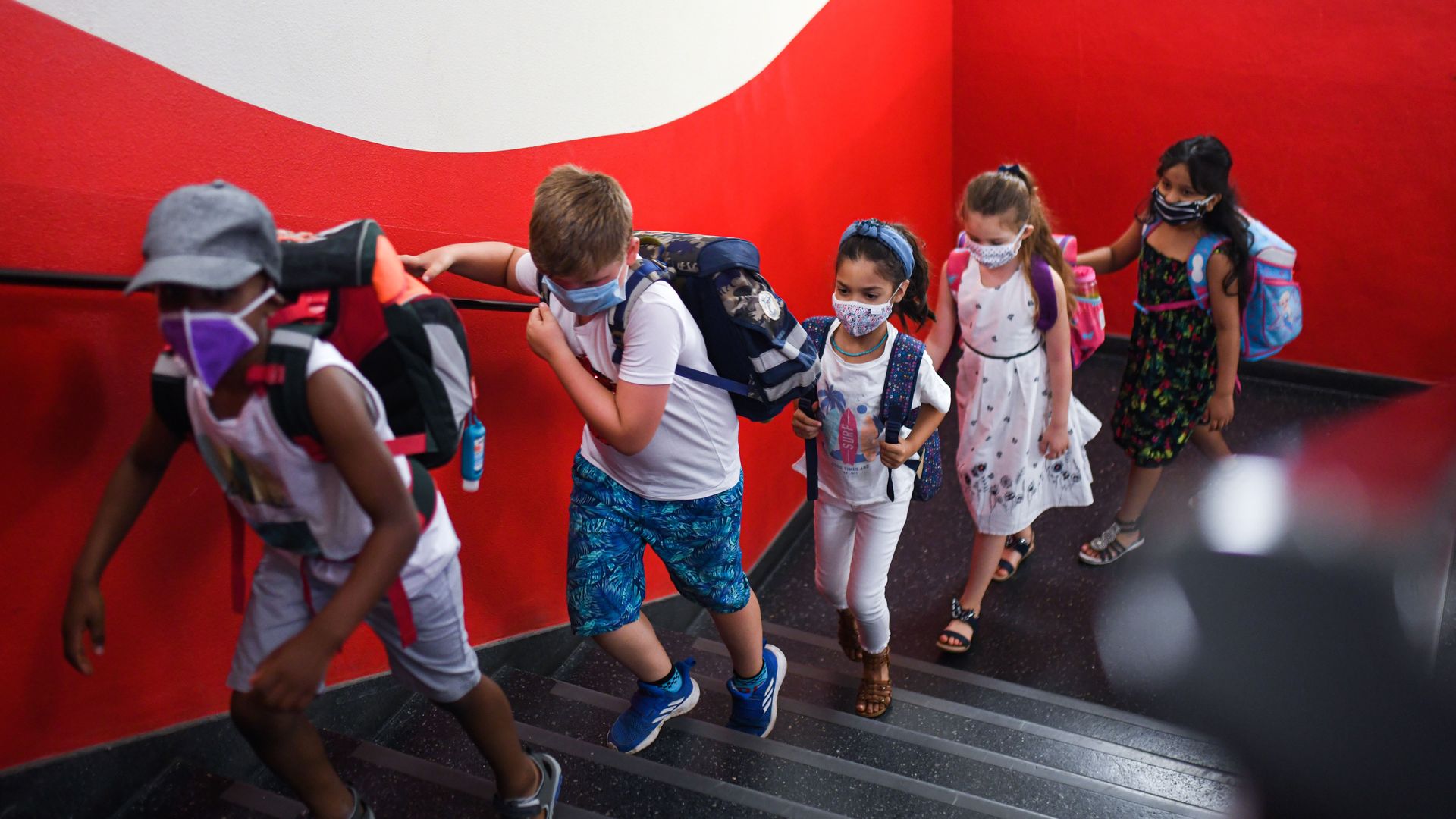 Students with face masks go upstairs to their classrooms.