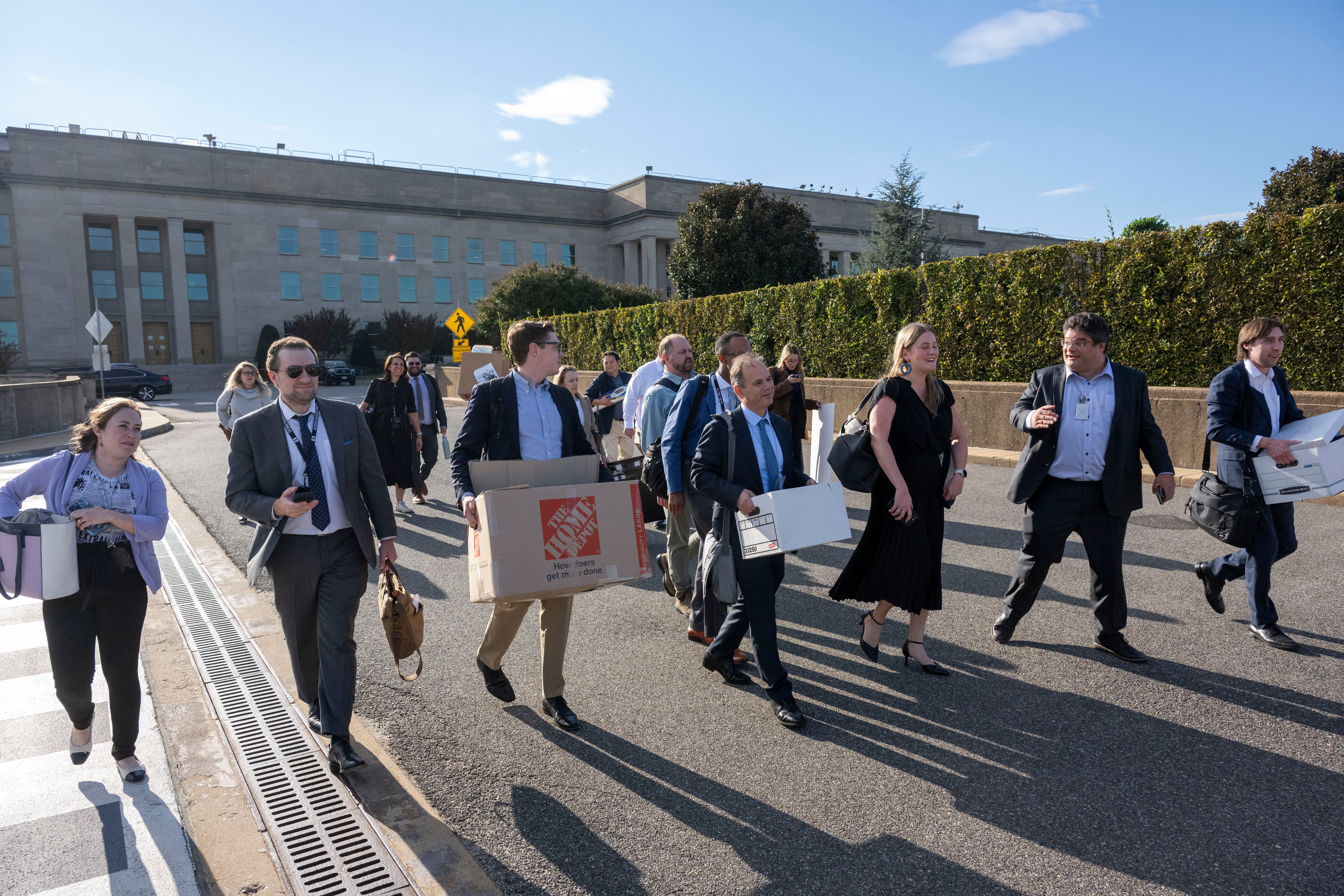 Members of the Pentagon press corps carry their belongings out of the Pentagon after turning in their press credentials.
