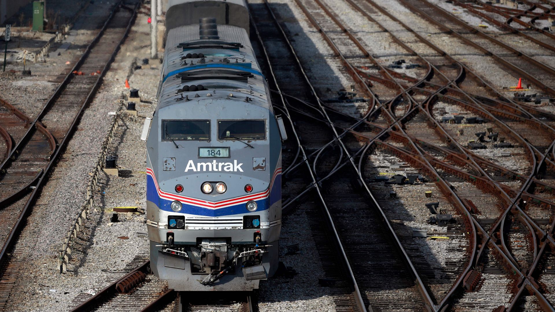 An Amtrak train leaves a railyard