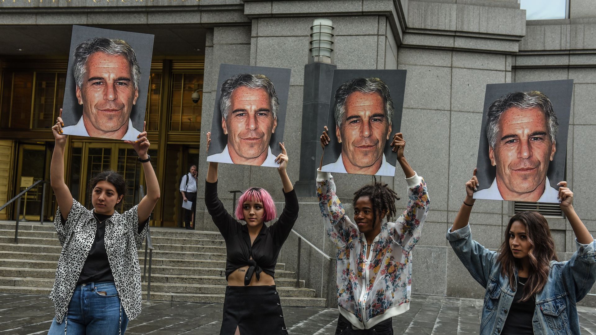  A protest group called "Hot Mess" hold up signs of Jeffrey Epstein in front of the Federal courthouse on July 8, 2019 in New York City.