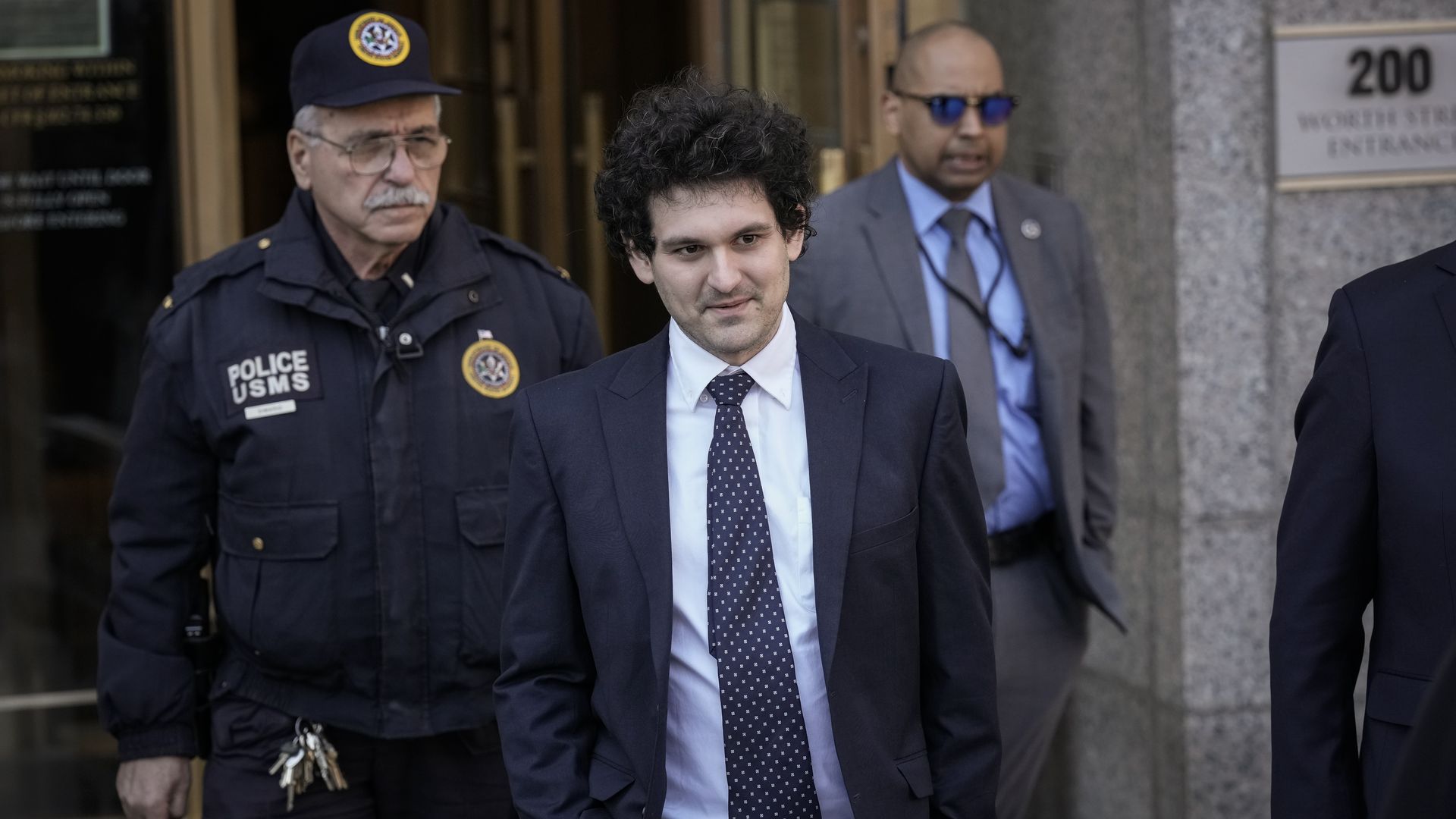 FTX founder Sam Bankman-Fried (C) departs Manhattan Federal Court after an arraignment hearing on March 30, 2023 in New York City.