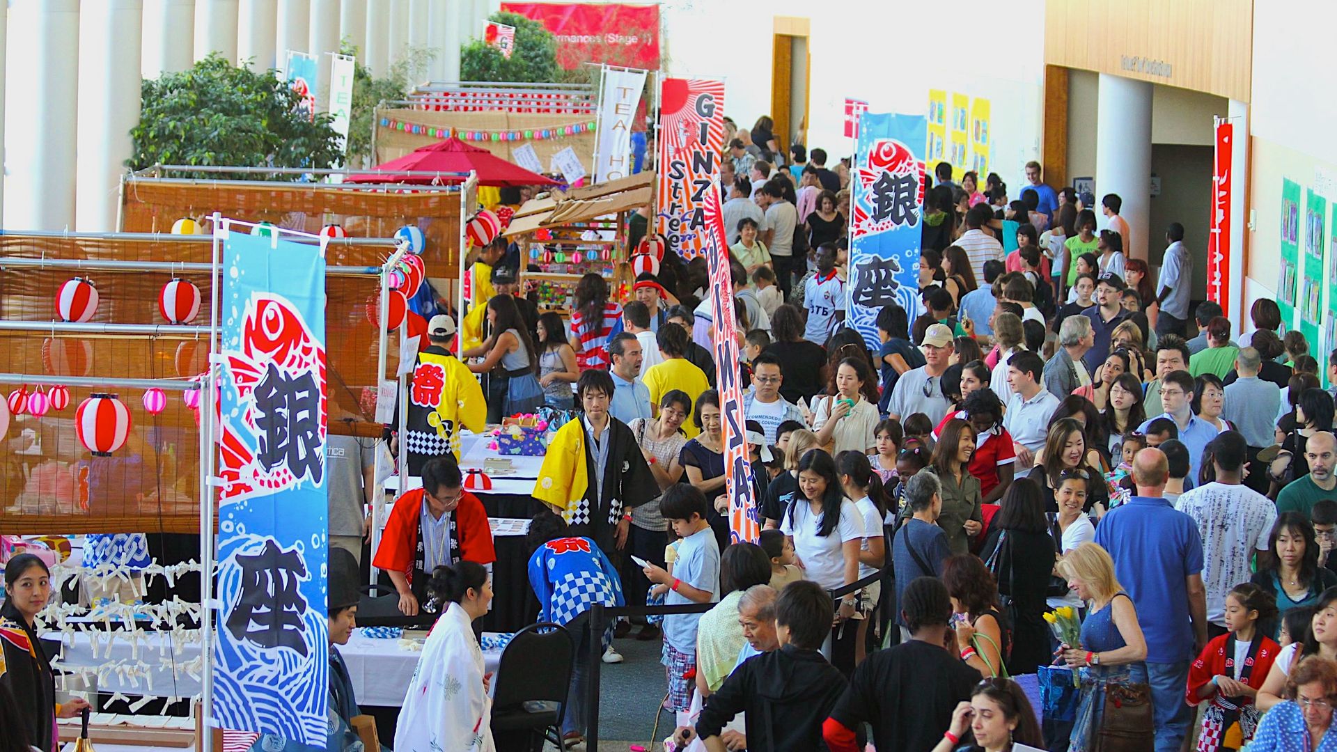 A photo of a large crowded convention center hallway with Japanese signs