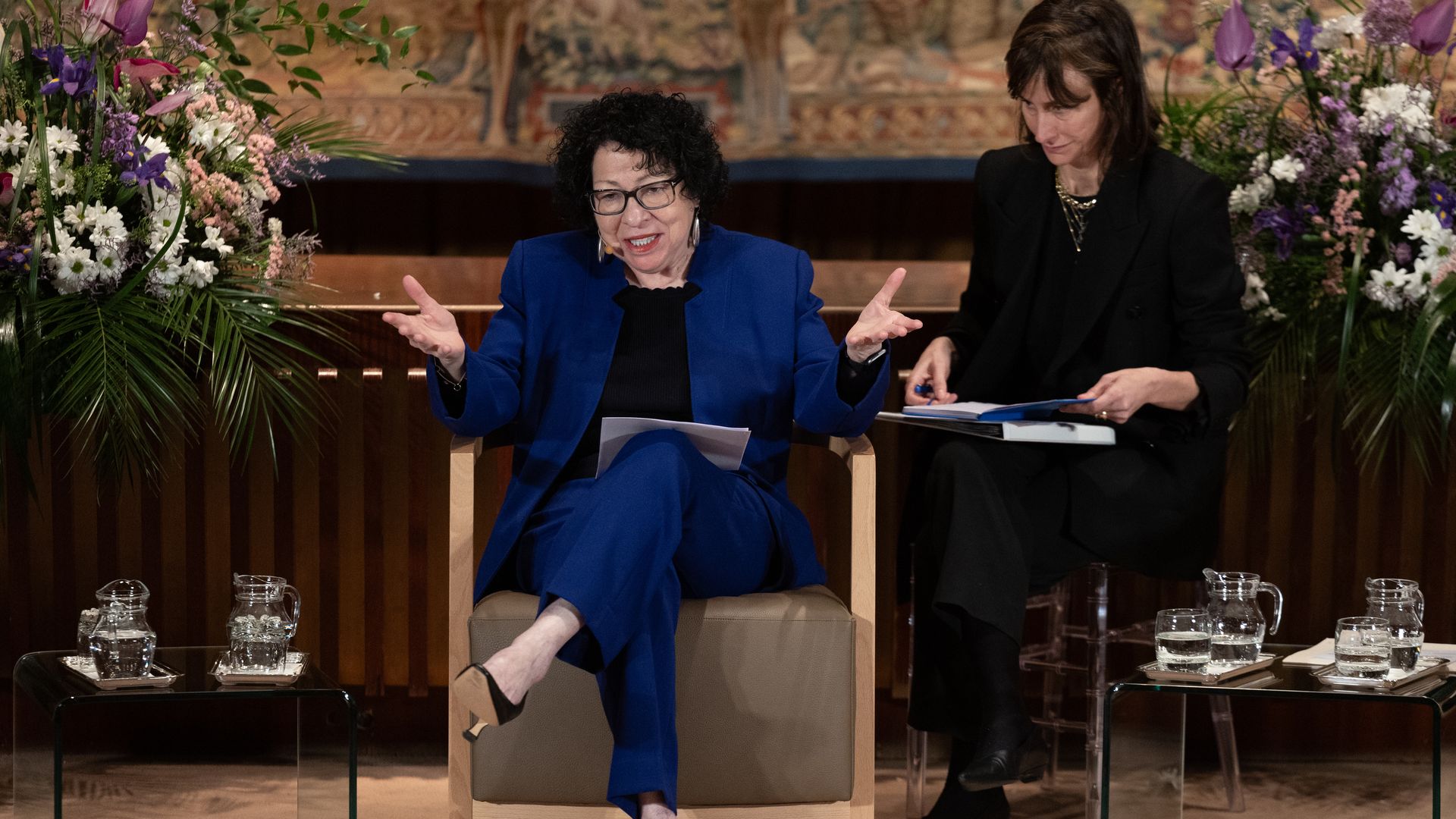Supreme Court Justice Sonia Sotomayor sits in a chair and speaks at a Women's Day event.