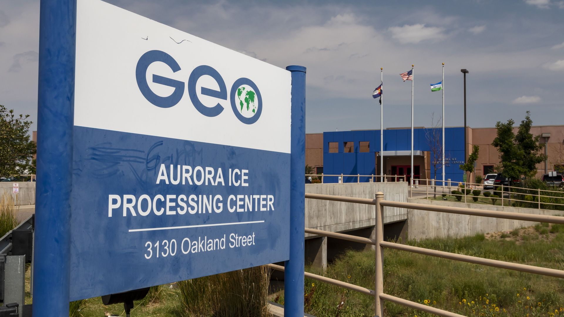 A photo of a blue and white sign that says Aurora ICE Processing Center