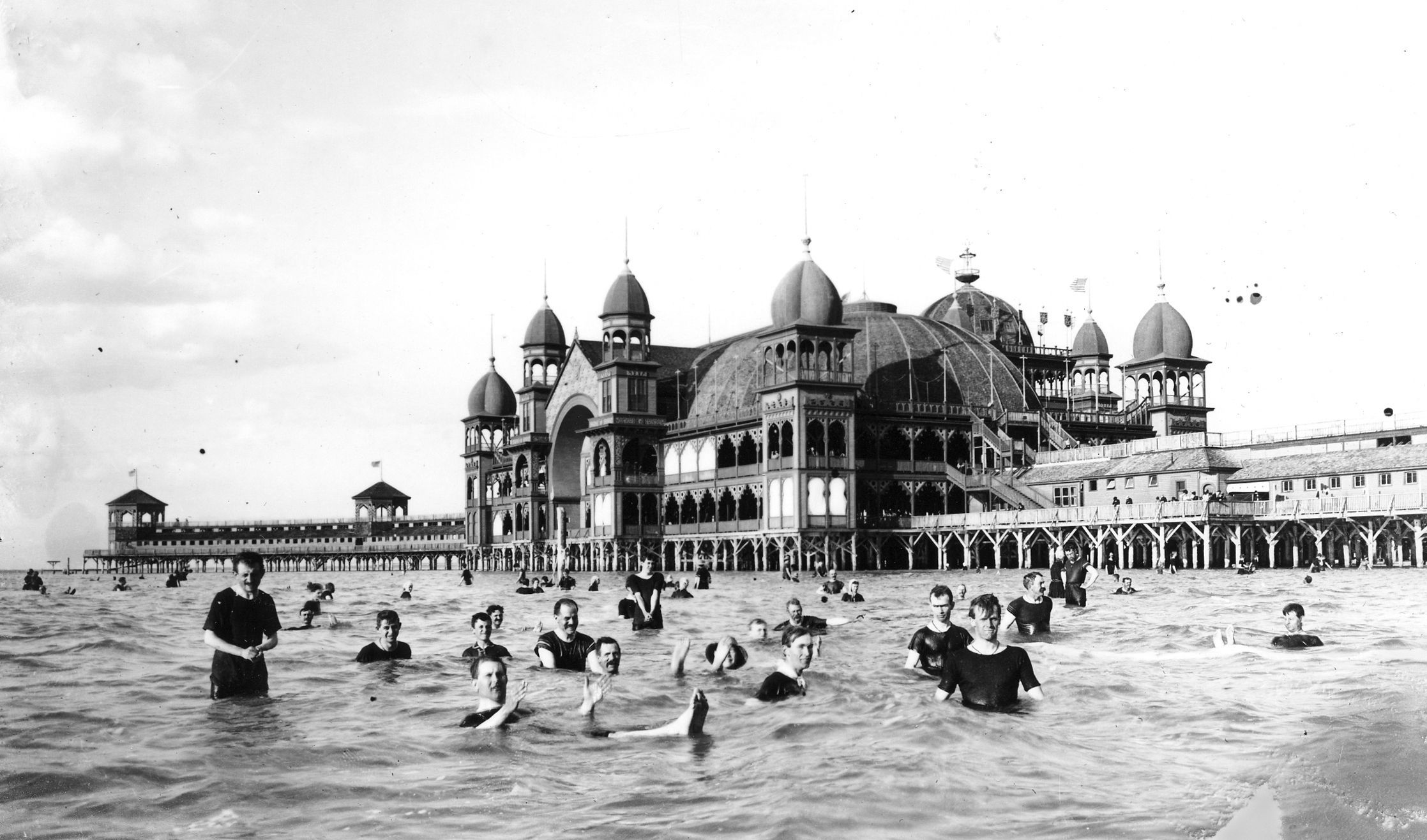 A vintage black-and-white photograph of people swimming at the Saltair resort in Utah, along the Great Salt Lake, in 1933.
