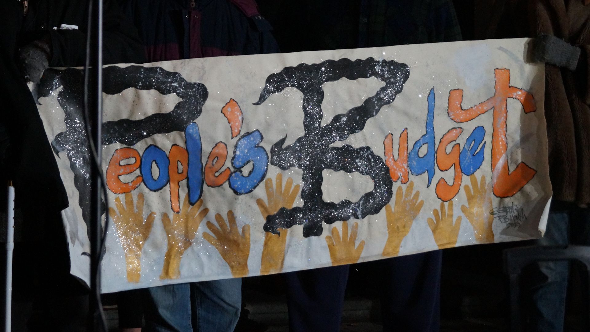 Members of the PB Cle coalition hold a handmade "People's Budget" sign on the steps of Cleveland City Hall.  