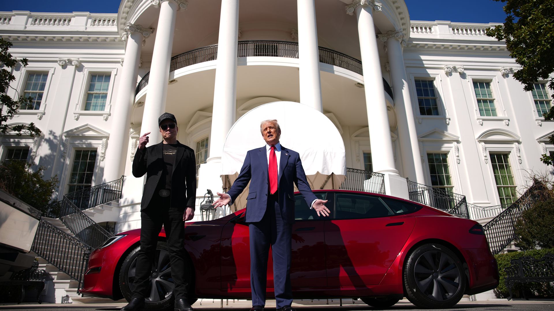 Two men and red car in front of White House