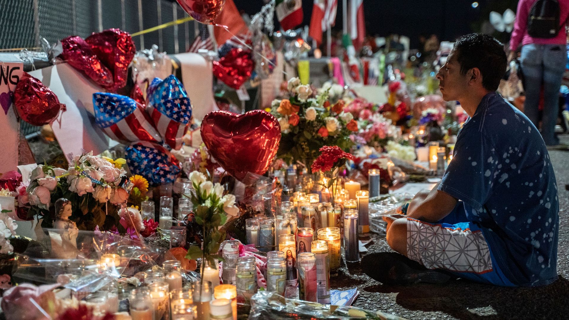 A man sitting at a memorial for El Paso victims. 