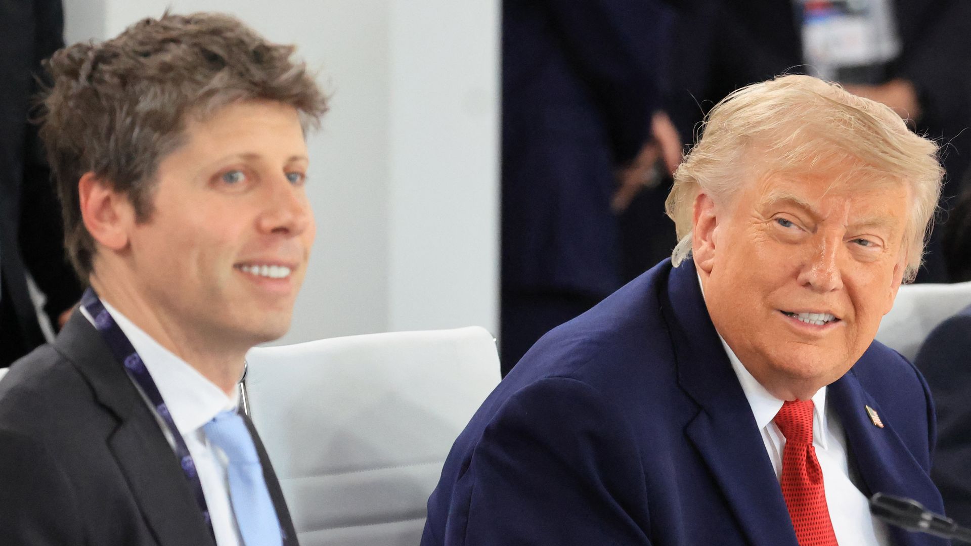 Two people in suits and ties smile