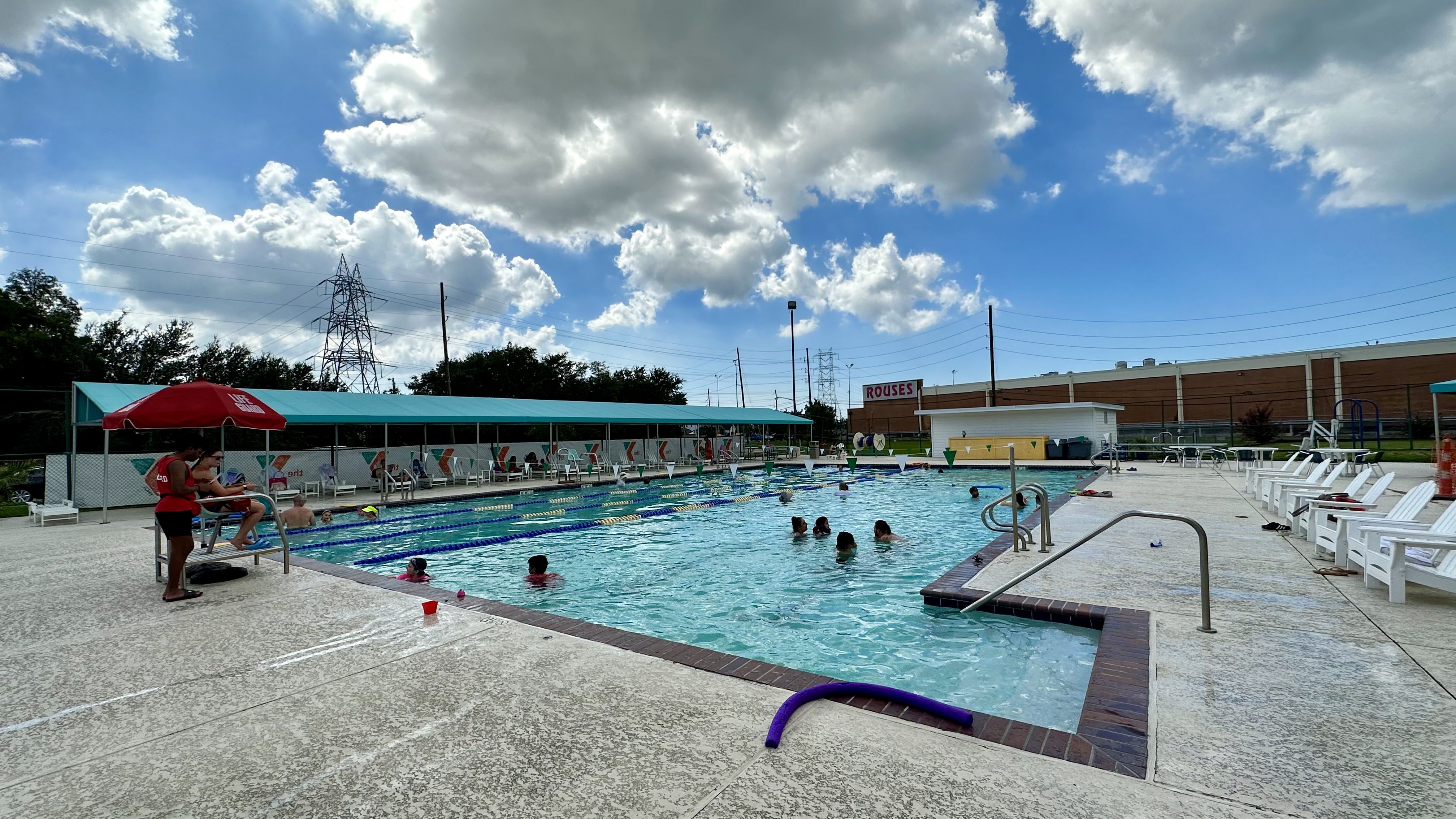 Photo shows a pool with lifeguards