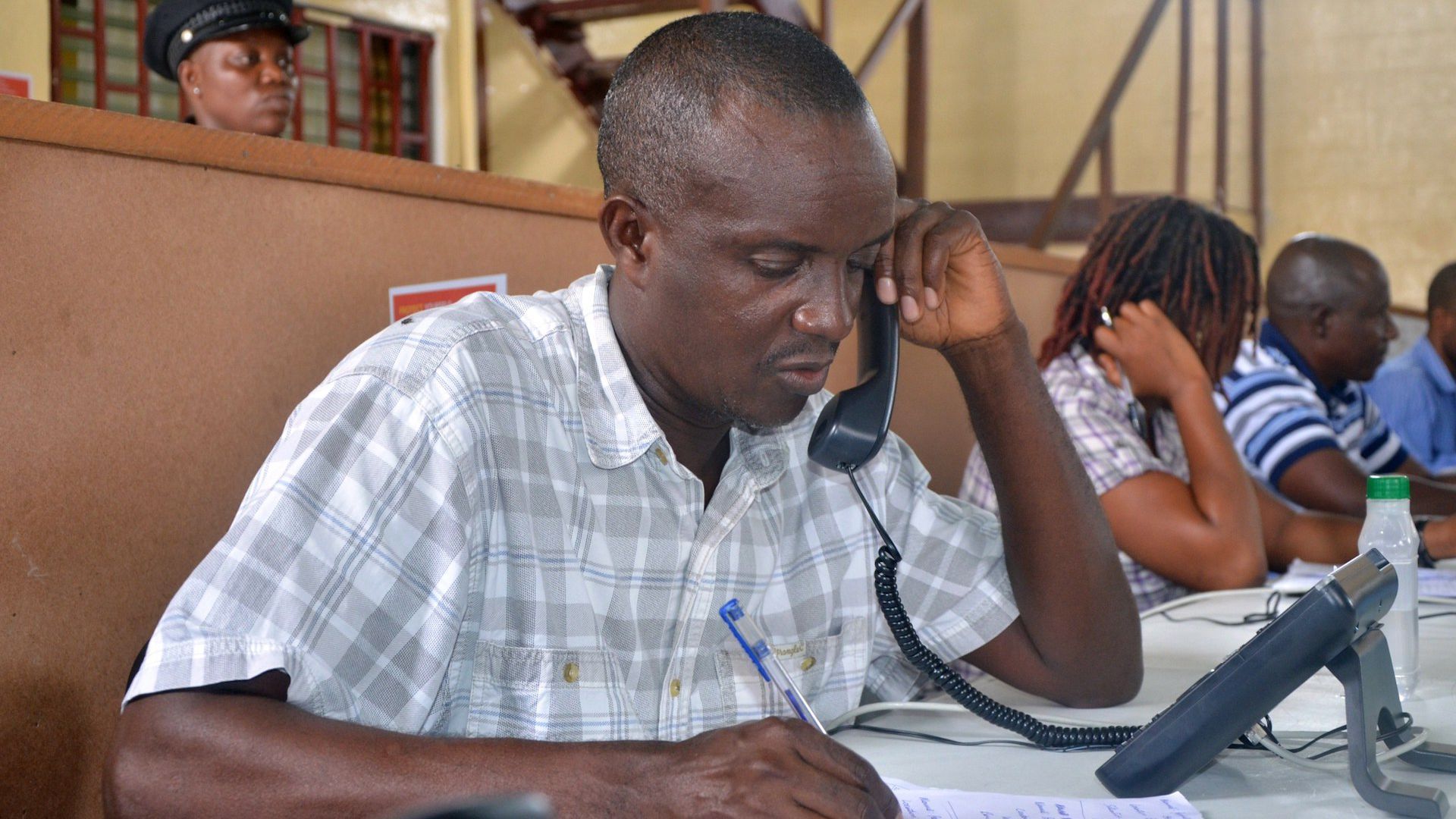 A man speaks on the phone at a call center in the Liberian capital Monrovia, where people can report Ebola cases, on August 9, 2014.