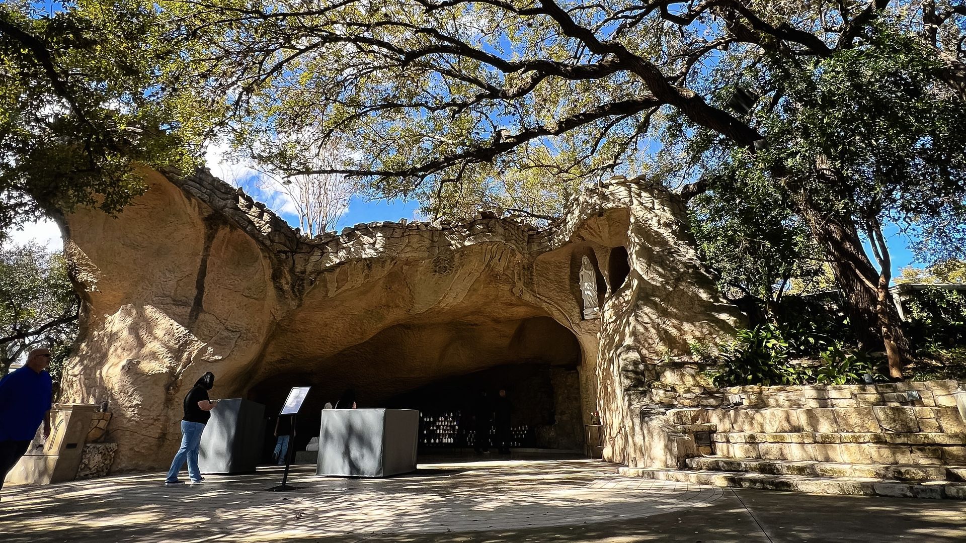The beige-colored grotto surrounded by sunny skies and trees.