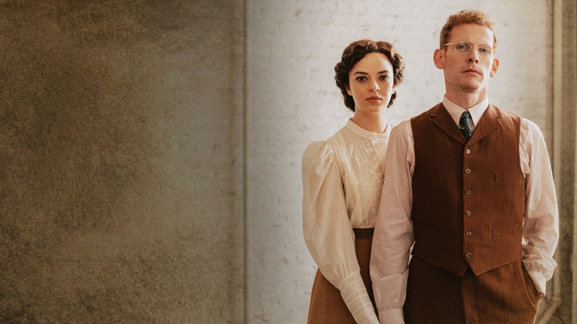 A man and a woman holding hands and looking at the camera
