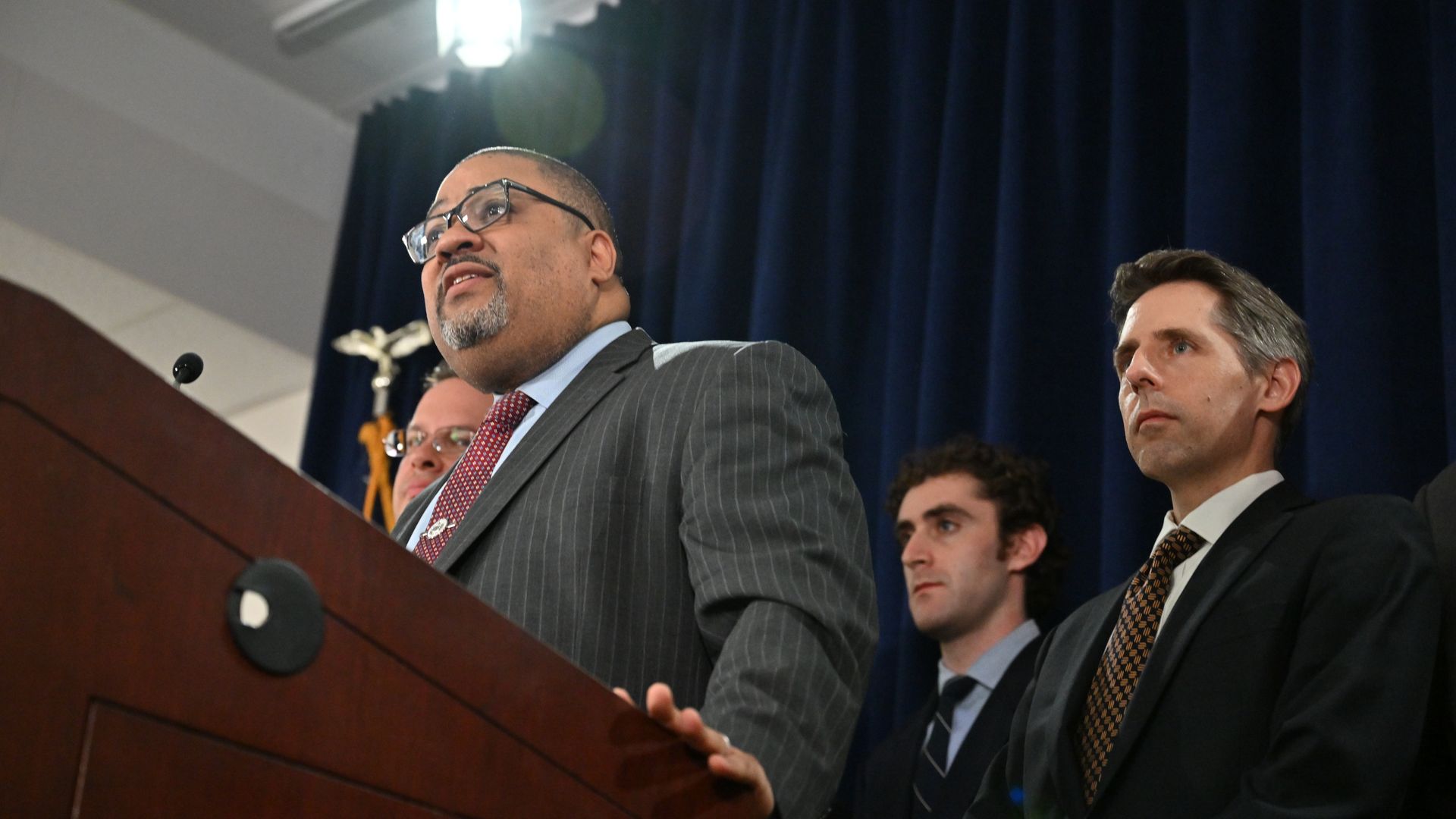 Alvin Bragg and others stand during a press conference
