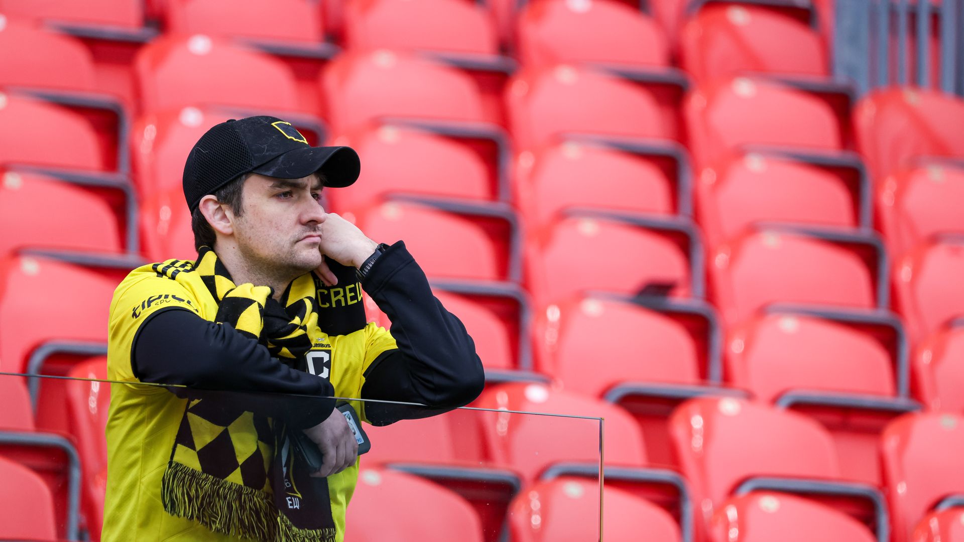 A Columbus Crew sits alone in the stands looking sad