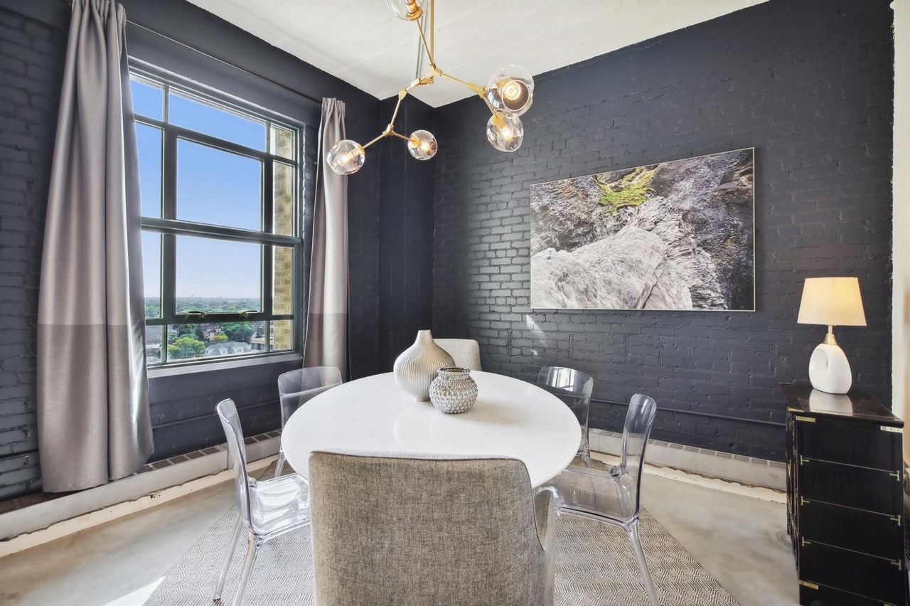 dining nook with brick accent wall and modern light fixture