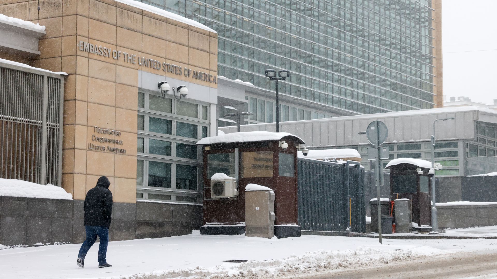 A person walking alongside the us embassy.
