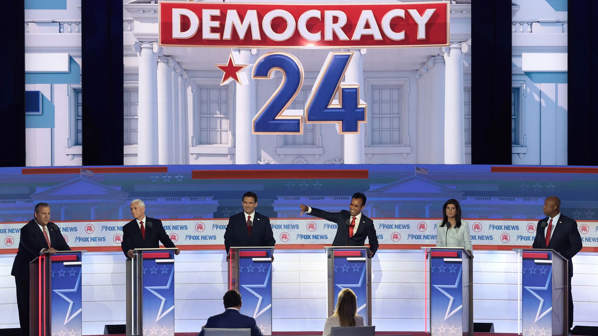 Candidates Chris Christie, Mike Pence, Ron DeSantis, Vivek Ramaswamy, Nikki Haley and Tim Scott stand behind podiums at the first Republican presidential debate.