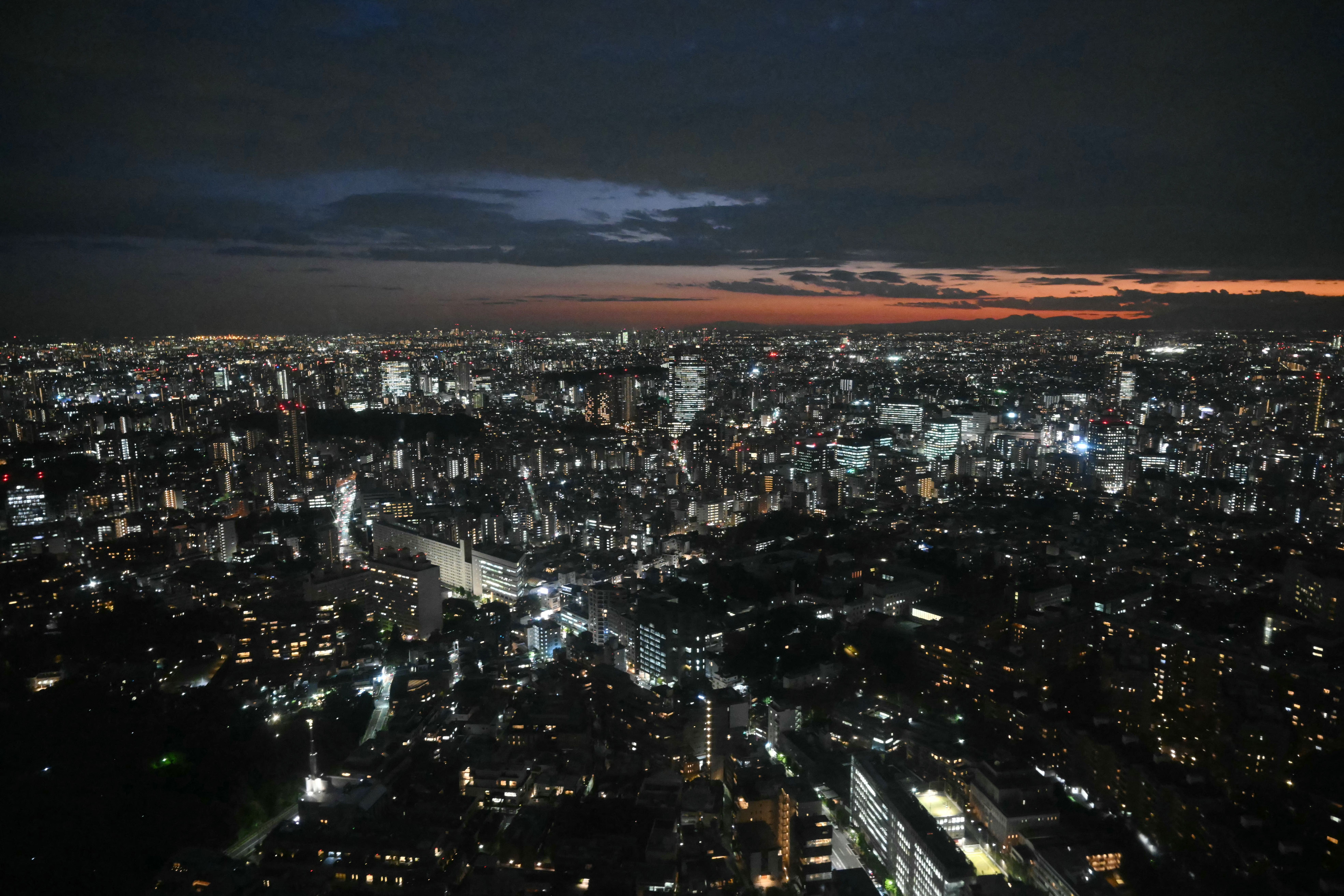 A view of downtown Tokyo is seen at dusk during a helicopter flight following US President Donald Trump's arrival in Tokyo on October 27, 2025. Donald Trump arrived in Japan on October 27, the next leg of an Asia tour that could see the US president and China's Xi Jinping end the bruising trade war