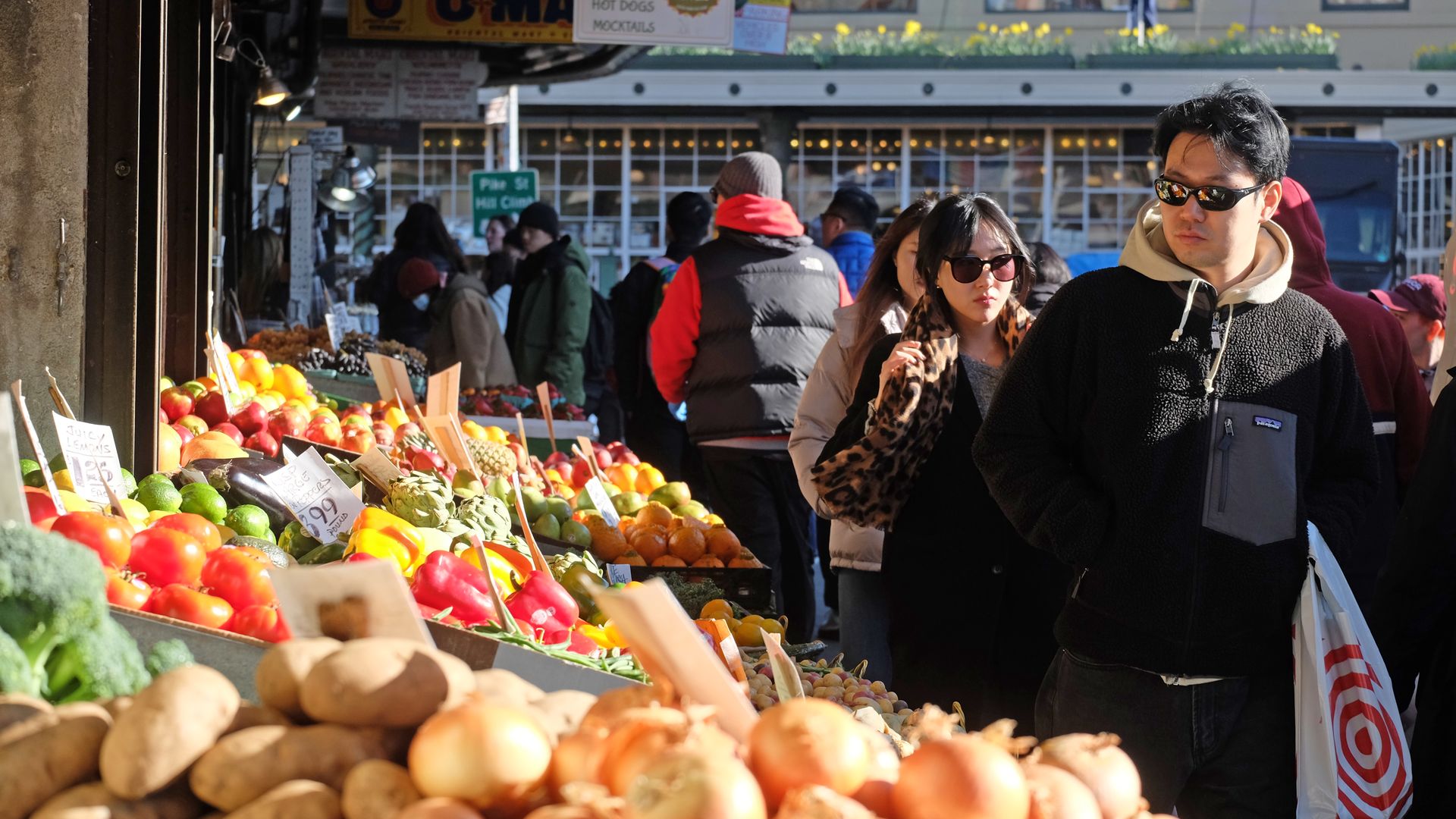Shoppers walk by a fruit display at Pike Place Market.