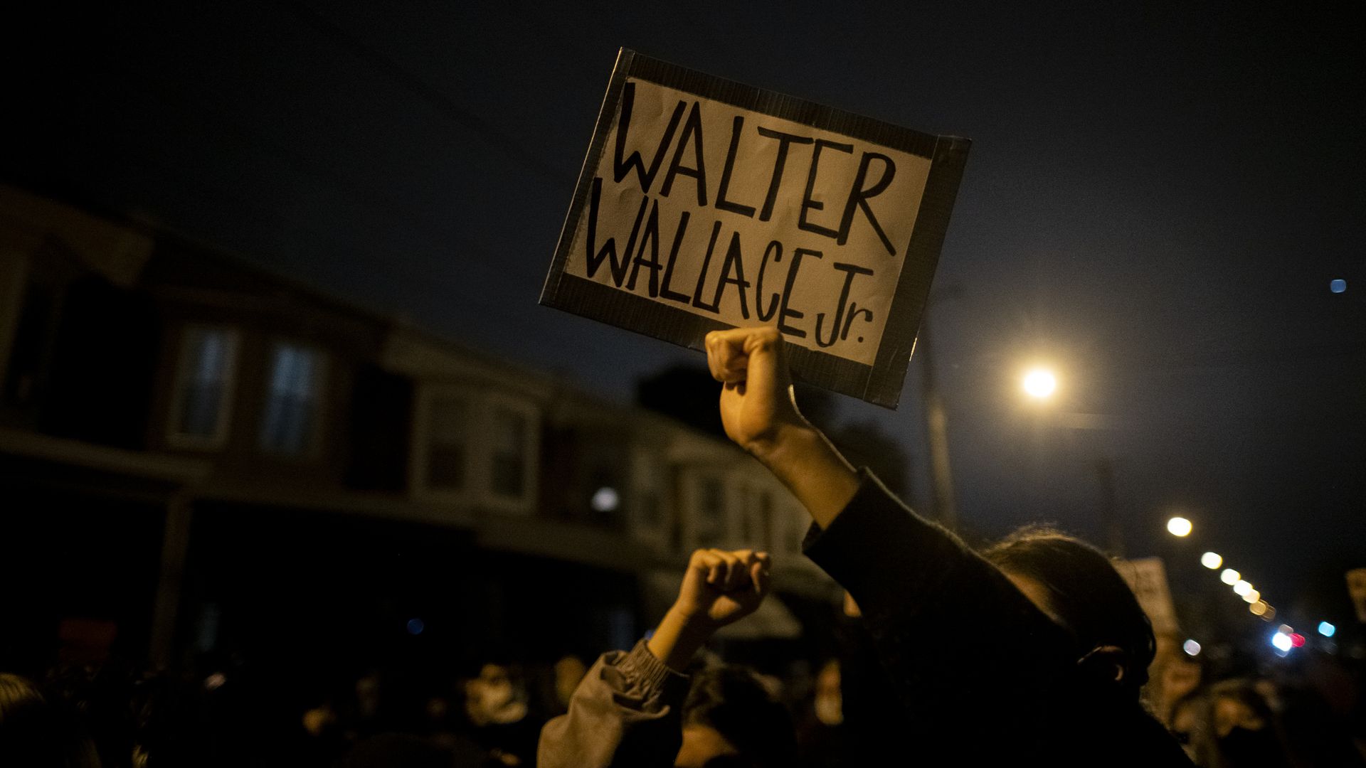 A demonstrator holding placard during a protest near the location where Walter Wallace Jr. was killed by two police officers on Oct. 26, 2020. Photo: Mark Makela/Getty Images