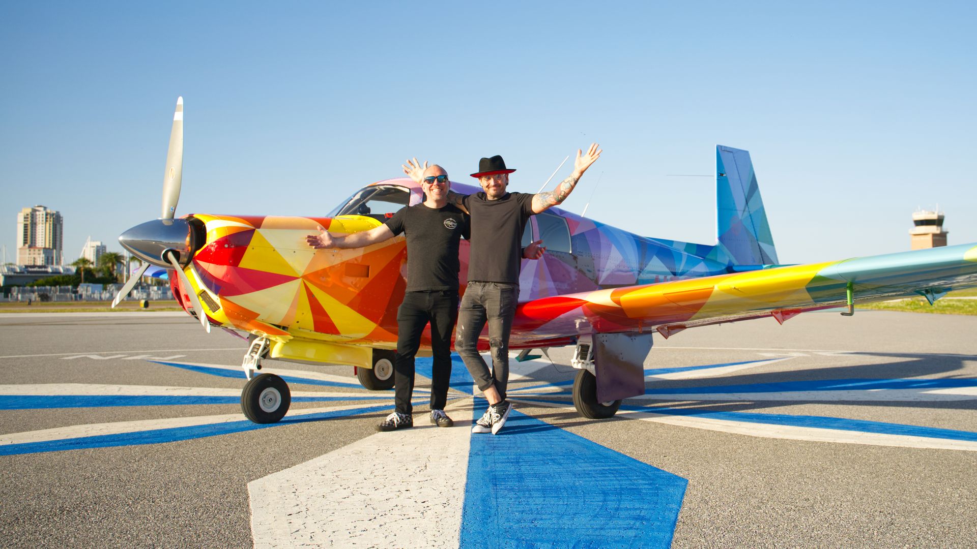 Liam Hawkins and Matt Kress pose in front of the "Mooney Anomaly" at Alfred Whitted airport