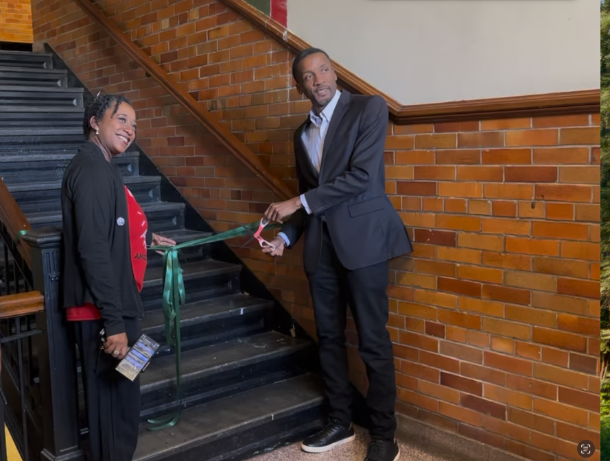 two people cutting a ribbon