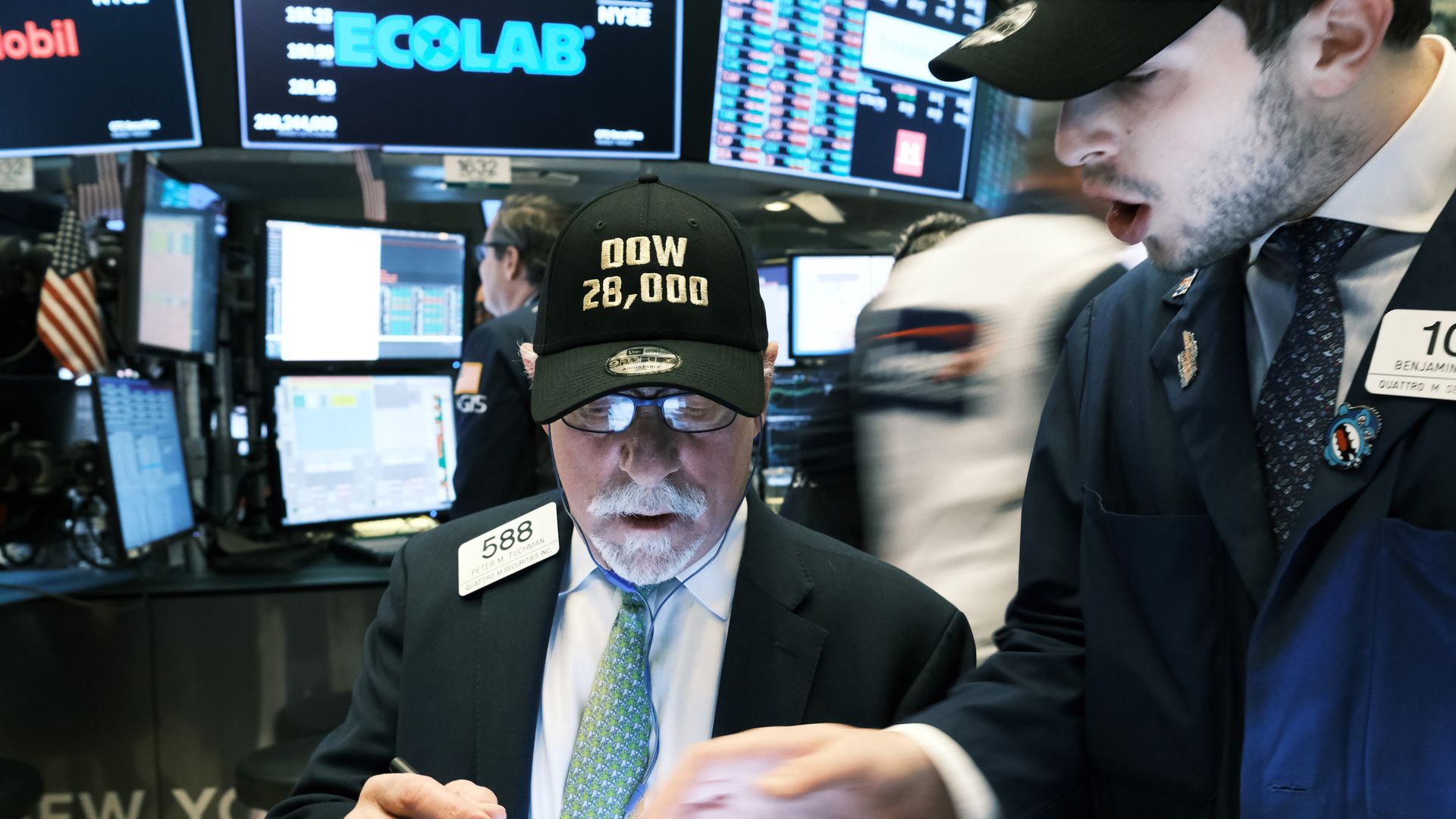 Traders wear "DOW 28,000" hats on the floor of the New York Stock Exchange (NYSE) on November 15, 2019 in New York City