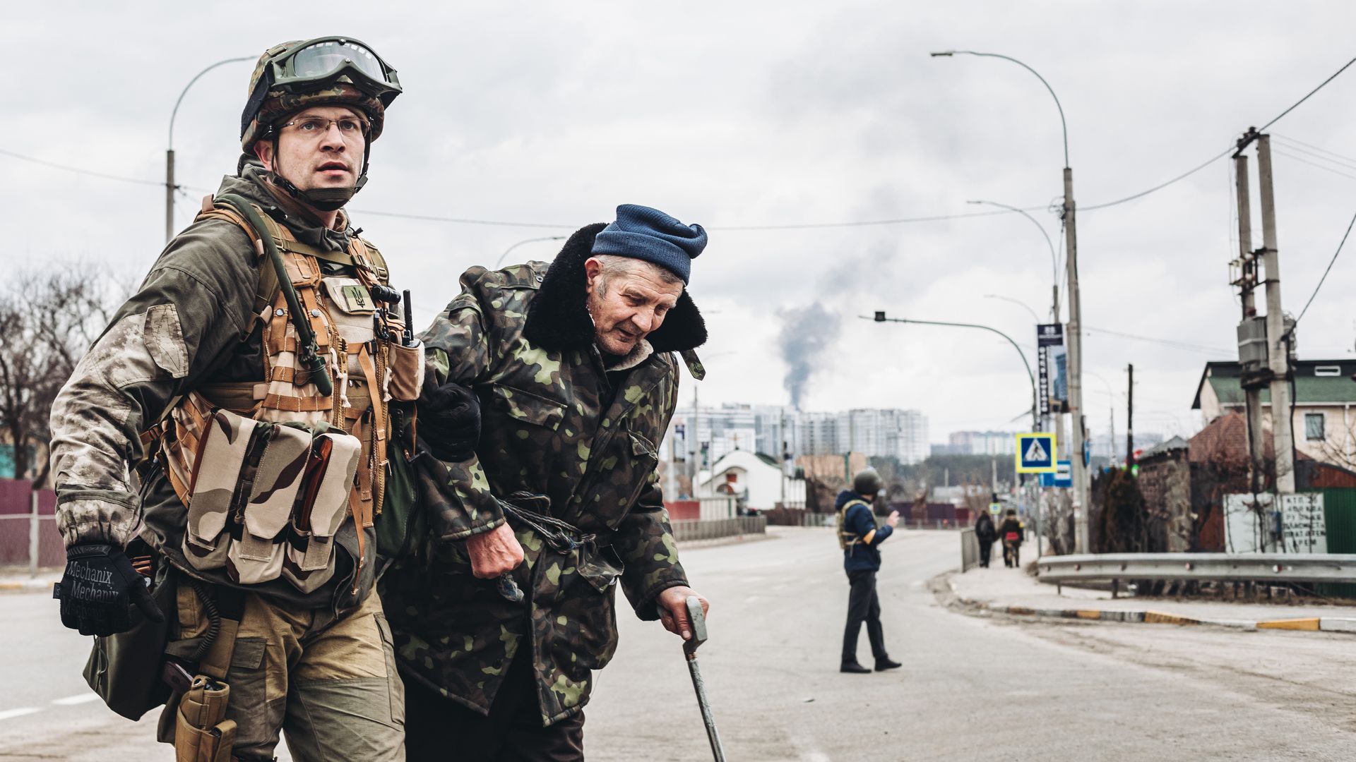 A soldier helps an elderly man escape shelling in Irpin, March 6, 2022, Ukraine.