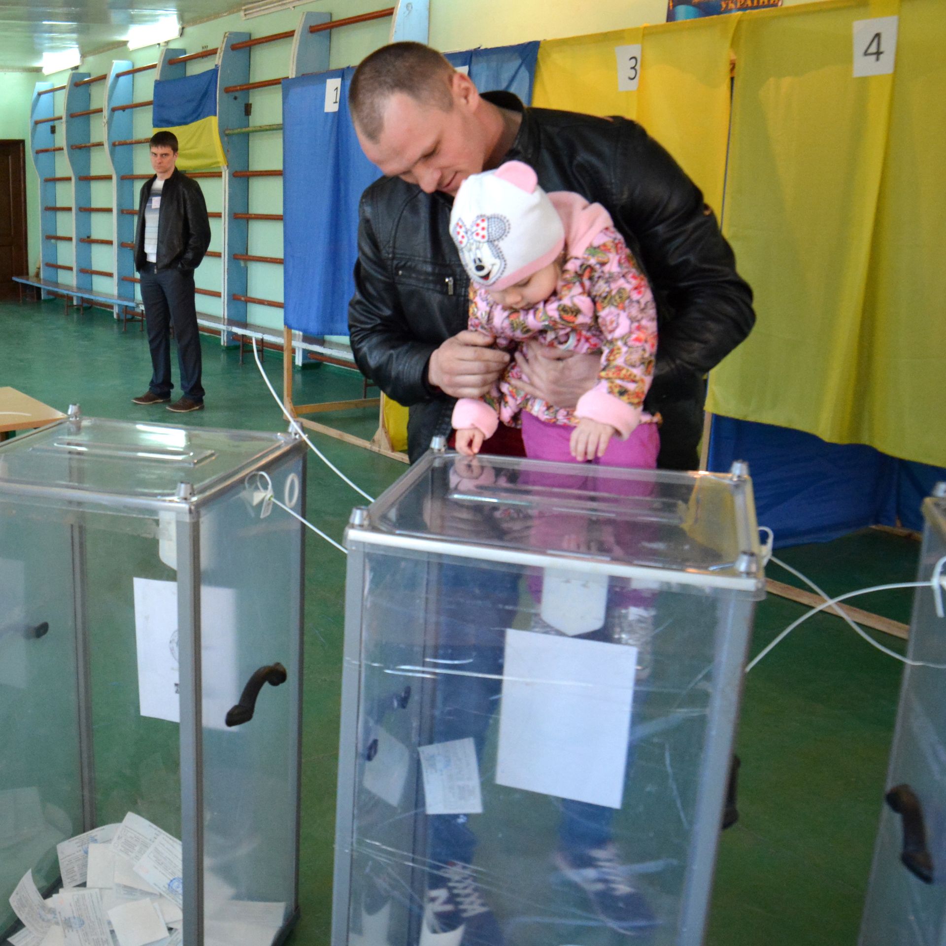 A man with his daughter casting his vote at a Ukrainian polling station