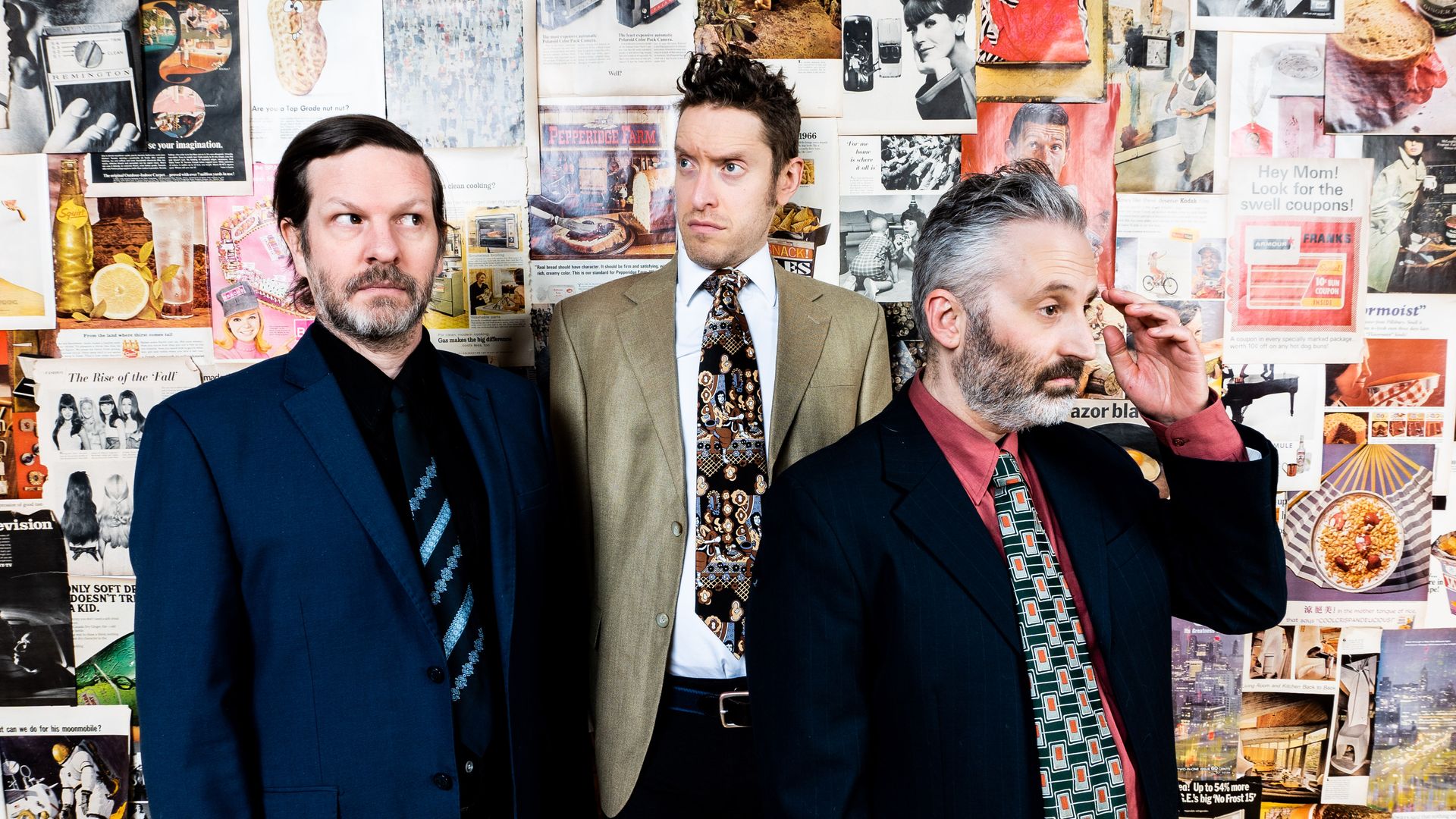 Photo of three men in suits posing for camera