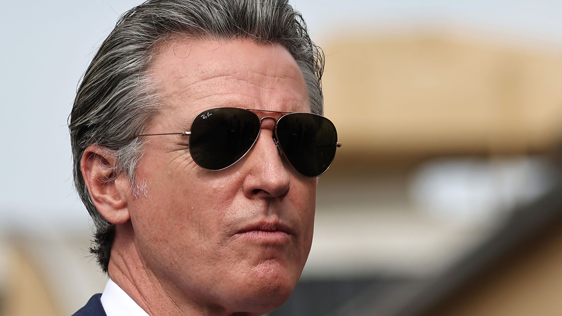 Governor Gavin Newsom wearing aviators with pursed lips