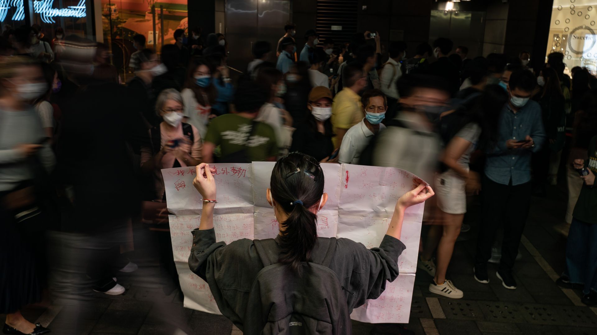 A resident holds a sign in protest of COVID restriction in mainland during a vigil in the central district on November 28, 2022 in Hong Kong, China. 