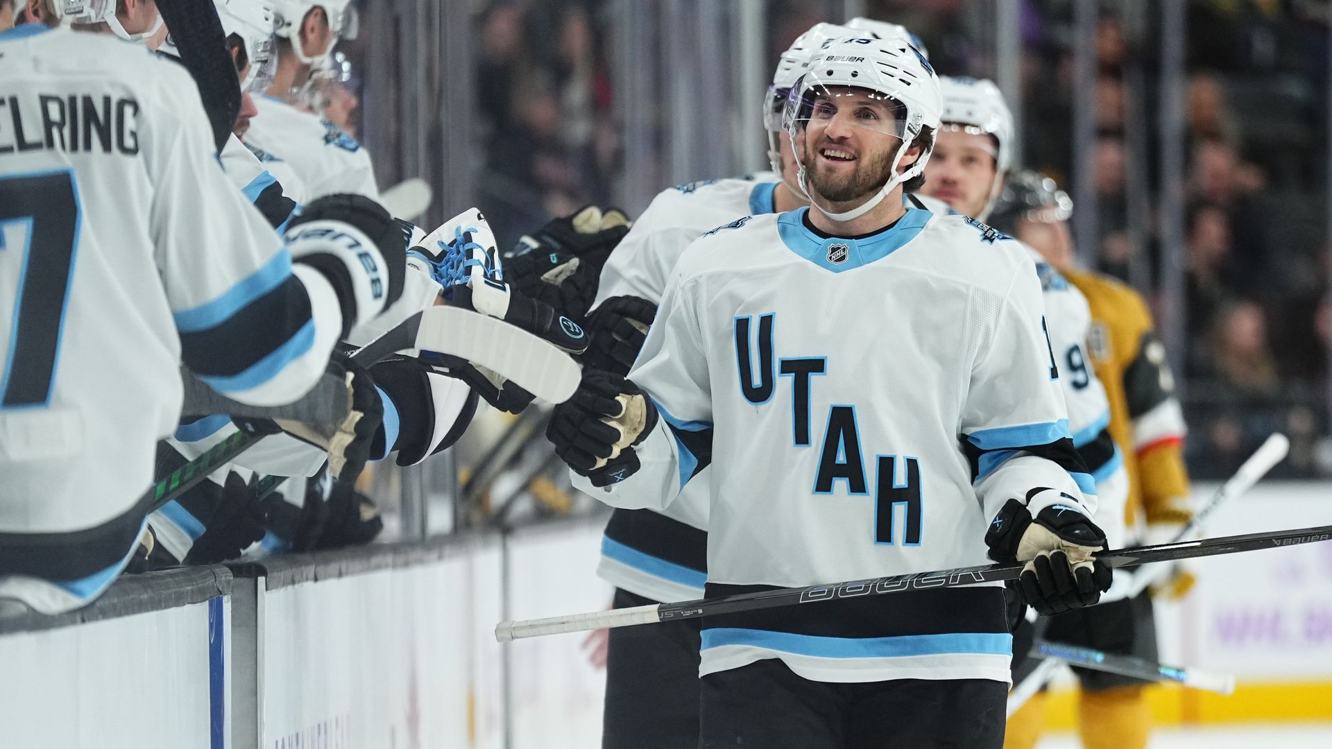 Utah Hockey Club teammates bump fists.