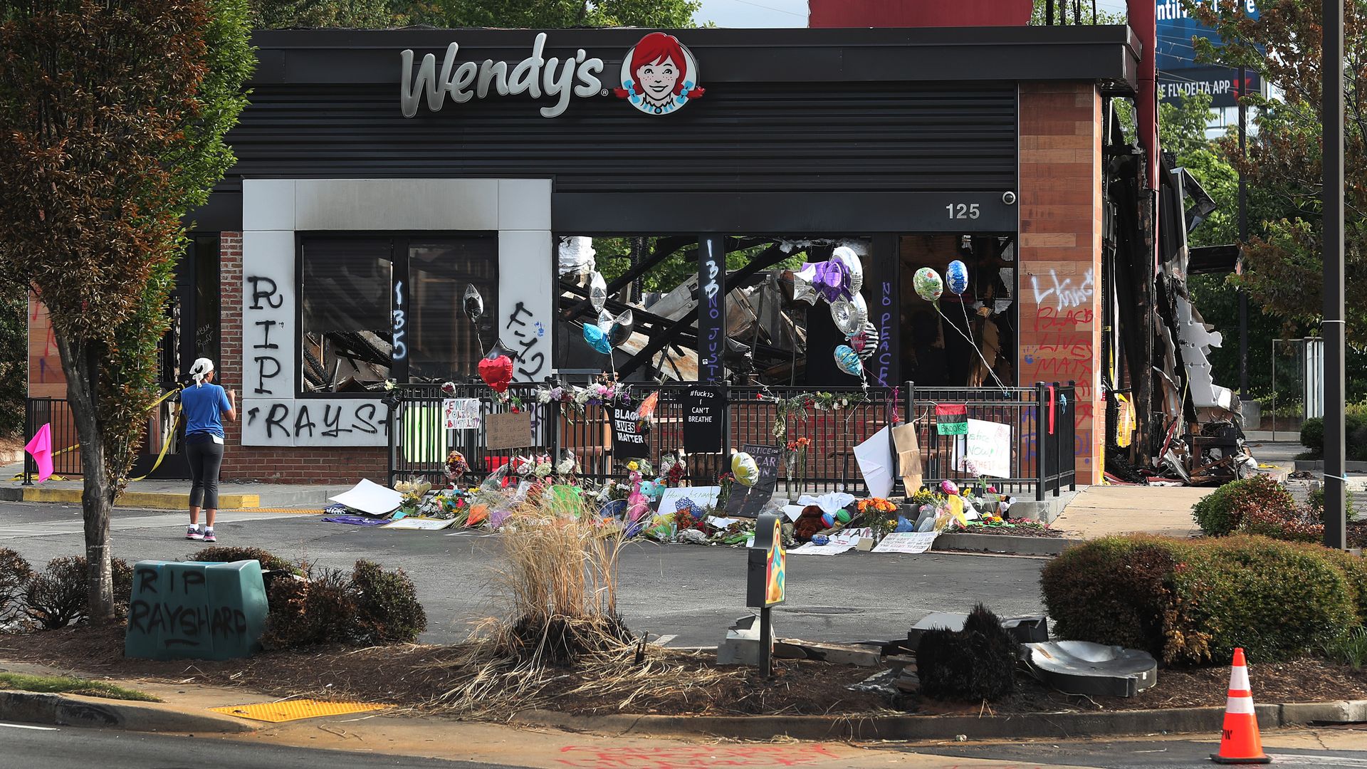 People visit the memorial setup outside the Wendy's restaurant that was set on fire by demonstrators 