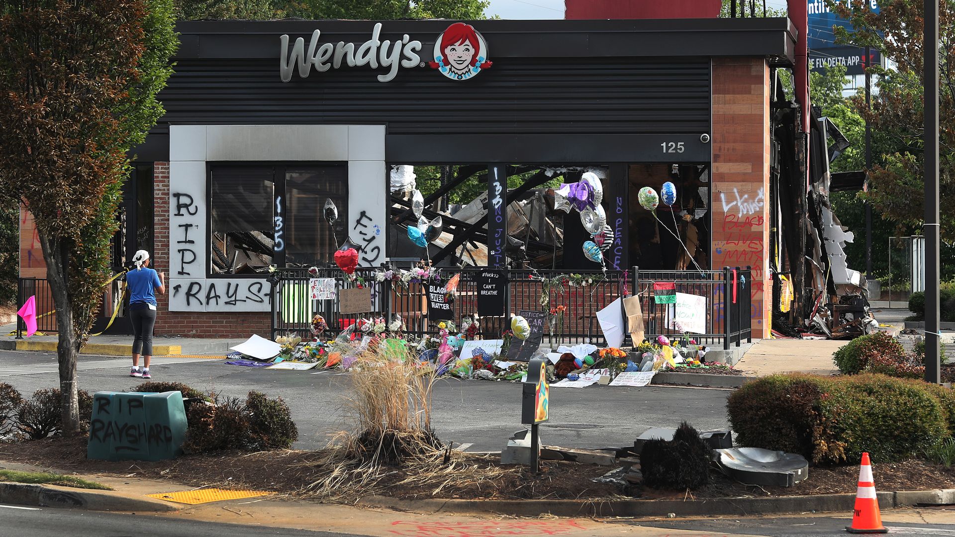 People visit the memorial setup outside the Wendy's restaurant that was set on fire by demonstrators