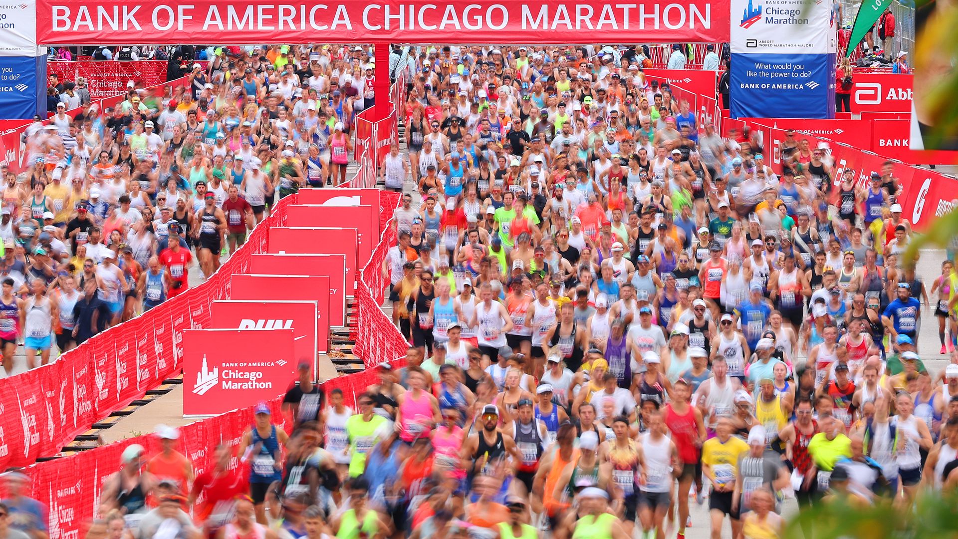 Photo of thousands of people running on a city street during a marathon. 