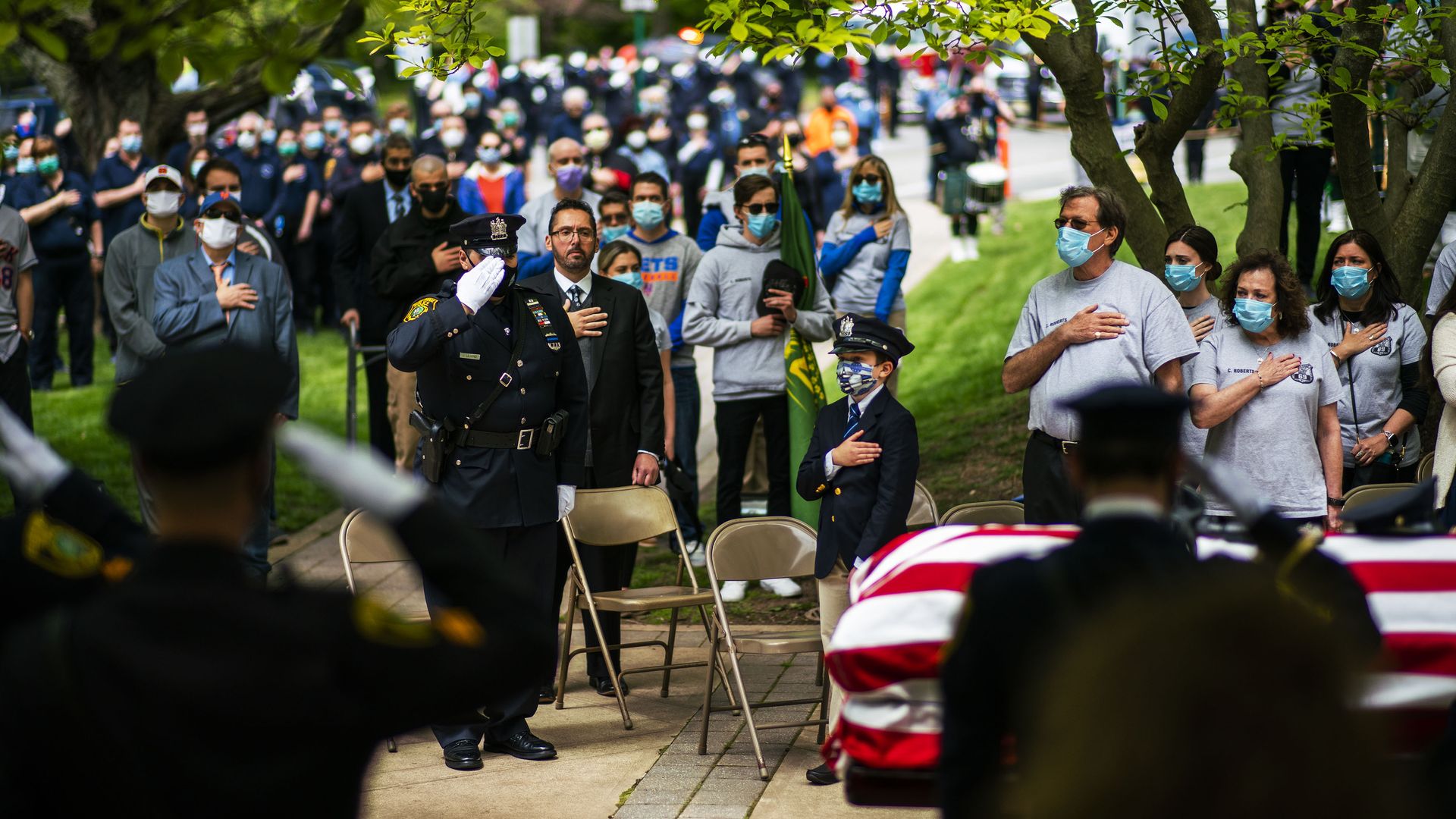 A photo of friends and family paying respects to a police officer who died from the coronavirus. 