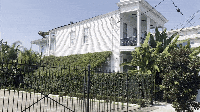 A video zooms in on the roof of a white house, where a lion statue is installed.