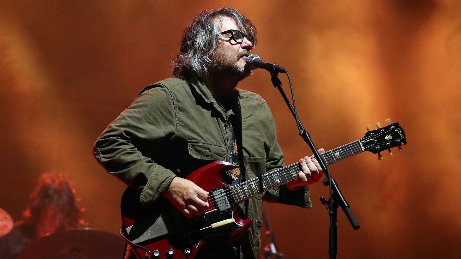 Photo of a man playing guitar on stage 