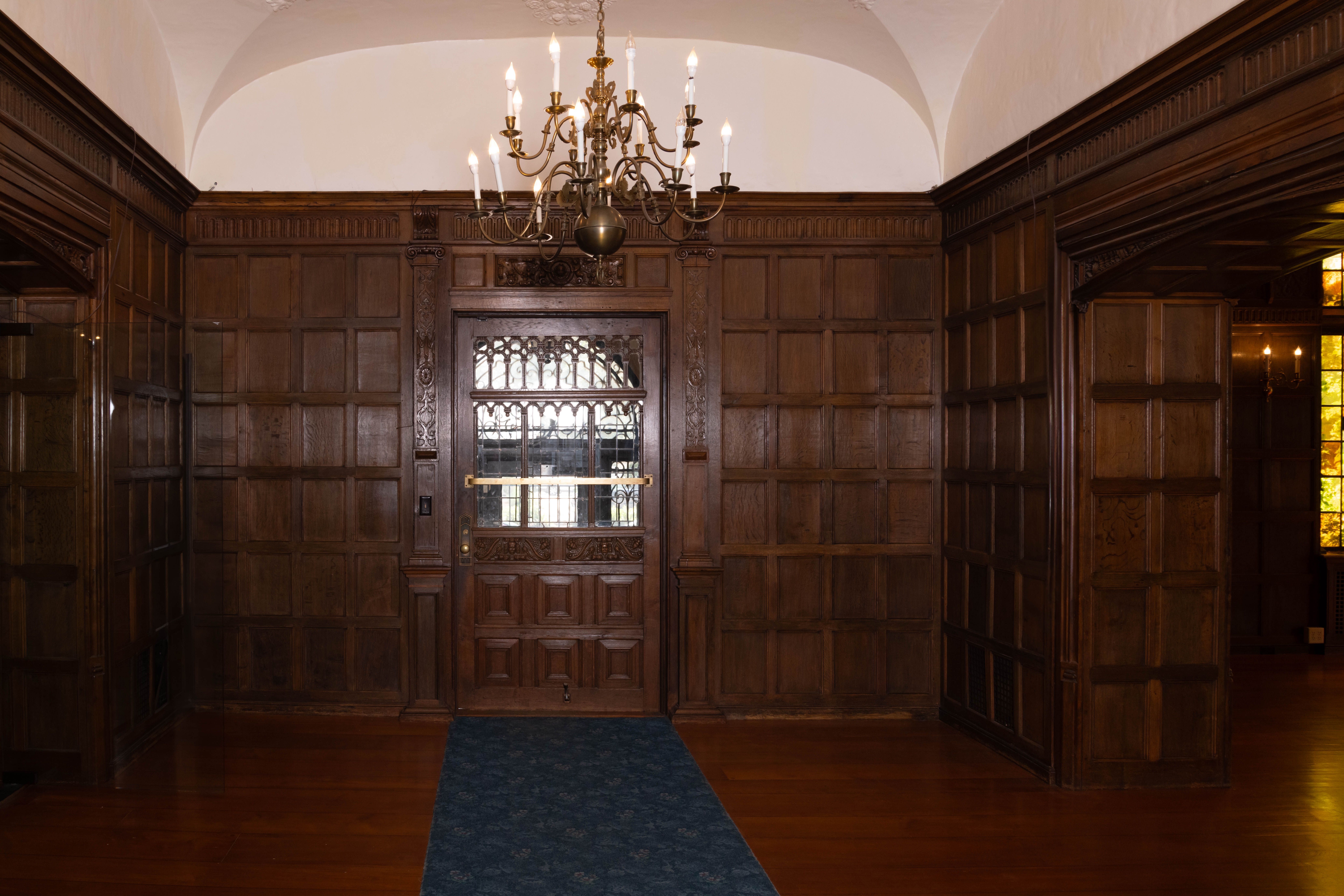An entryway with elaborate carved wood walls.