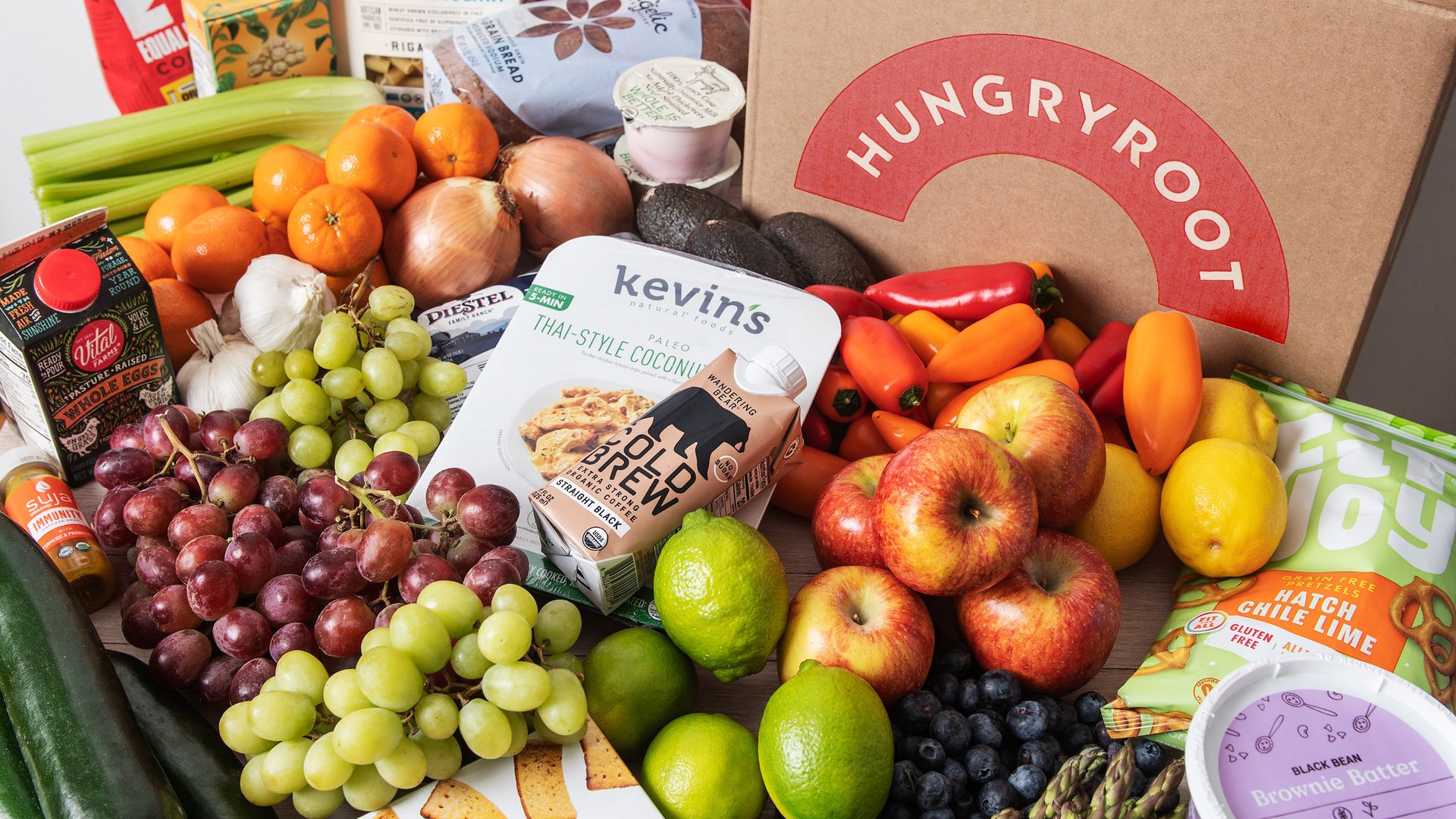 A Hungryroot-branded box surrounded by fruits, vegetables and other groceries.