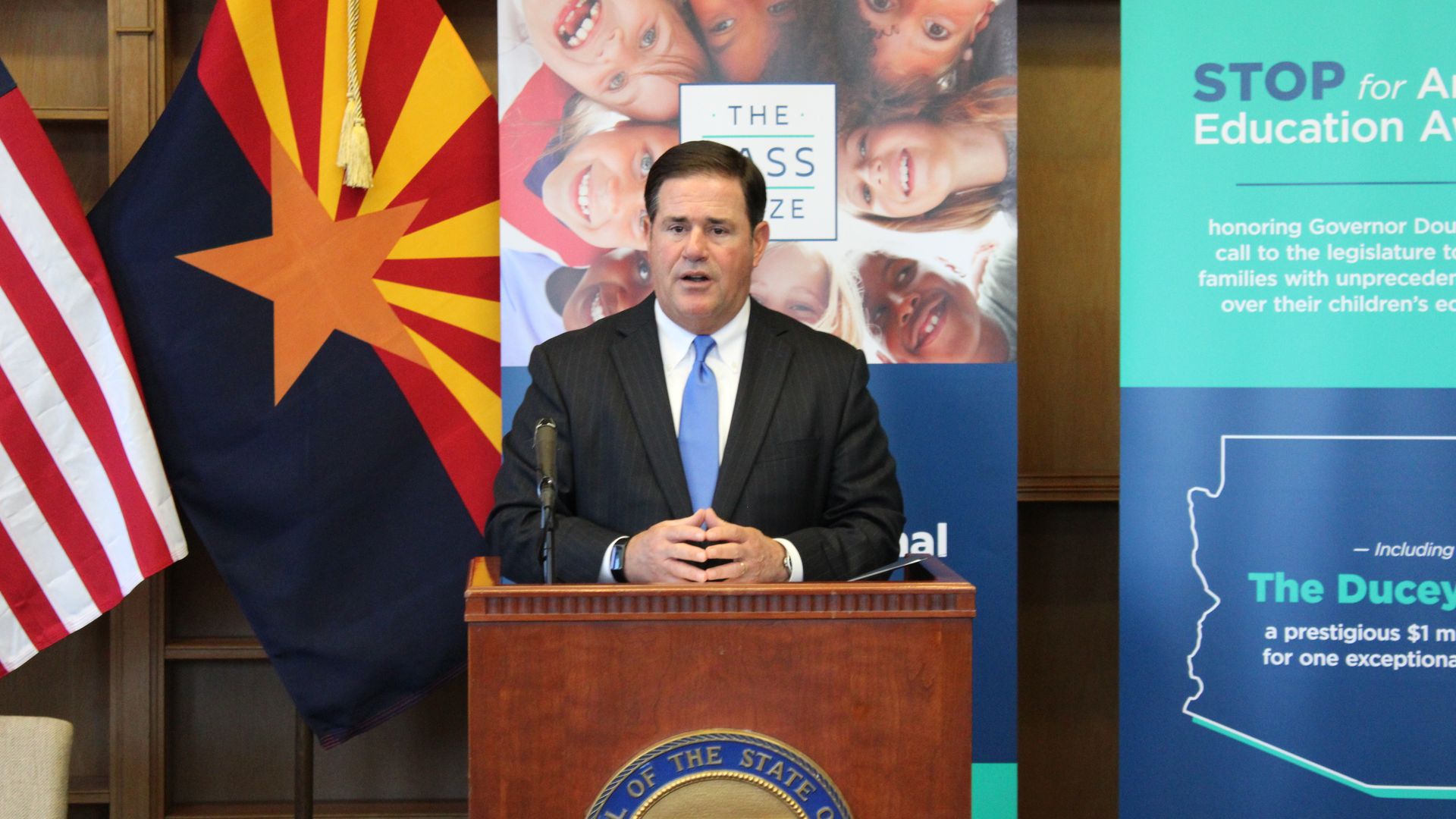 Arizona Governor Doug Ducey speaks behind a lectern