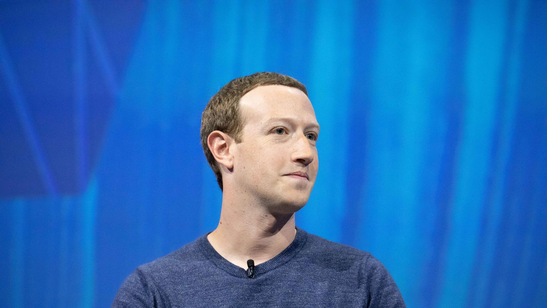 This is Mark Zuckerberg in front of a giant blue backdrop