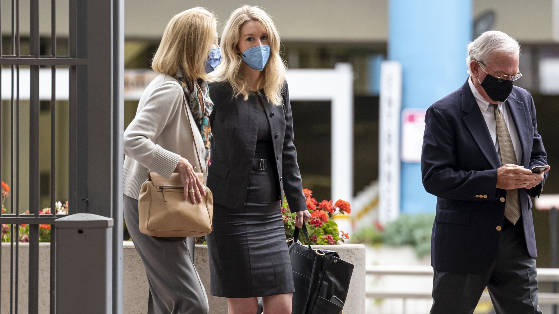 Elizabeth Holmes, founder of Theranos Inc., center, arrives at federal court in San Jose, California.