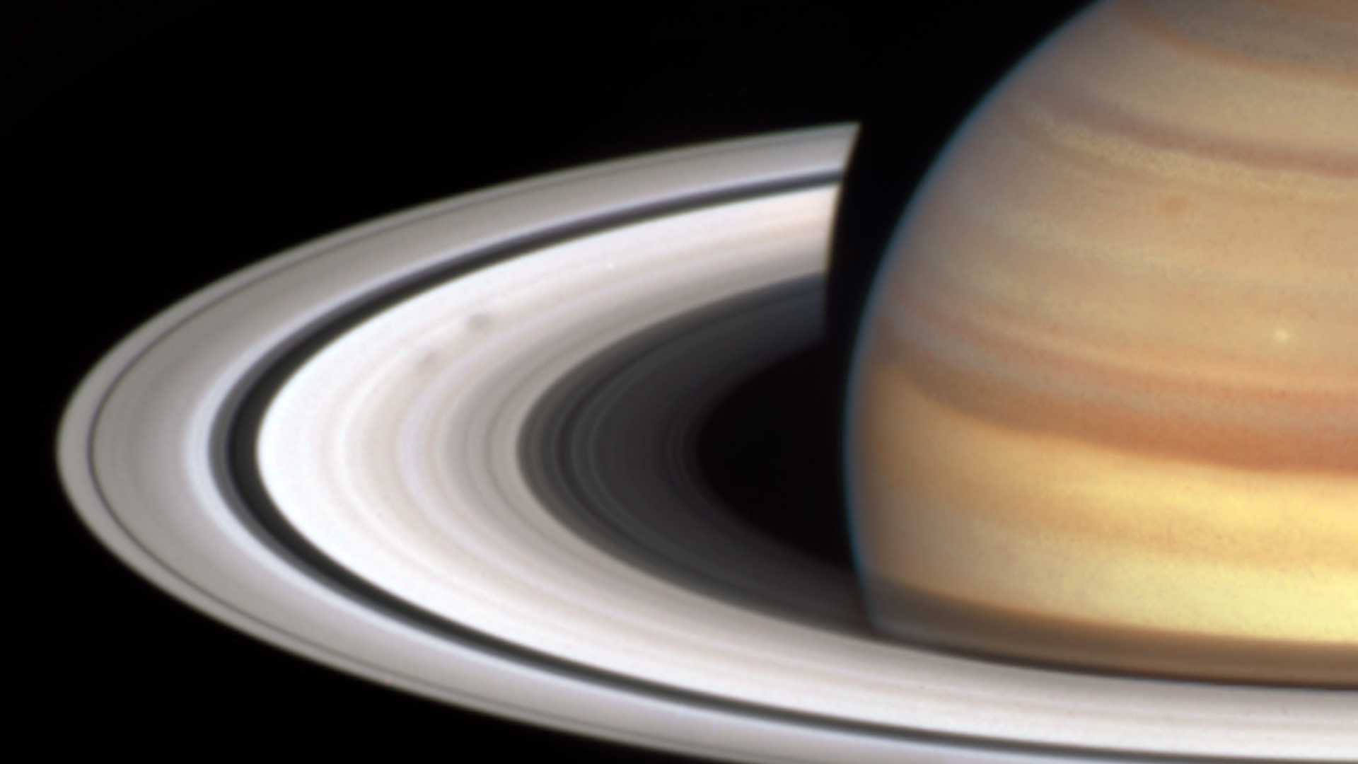 A part of Saturn see by the Hubble Space Telescope with two dark smudges known as 